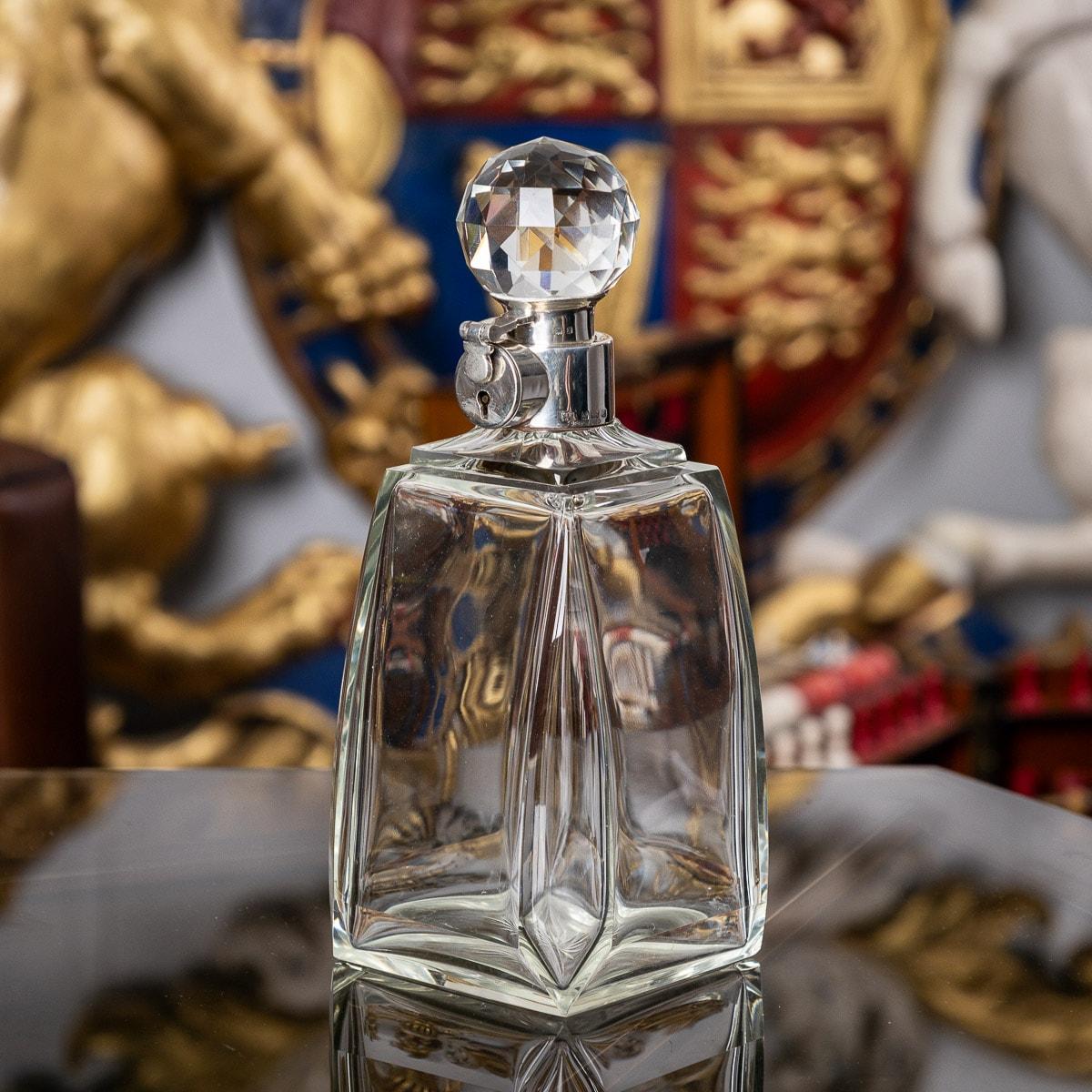 Carafe à alcool anglaise Art déco du 20e siècle en argent et en verre. De grande taille avec un corps en verre et monté avec un élégant bouchon taillé en forme de boule. Il est muni d'un collier argenté et d'un mécanisme de verrouillage avec clé.