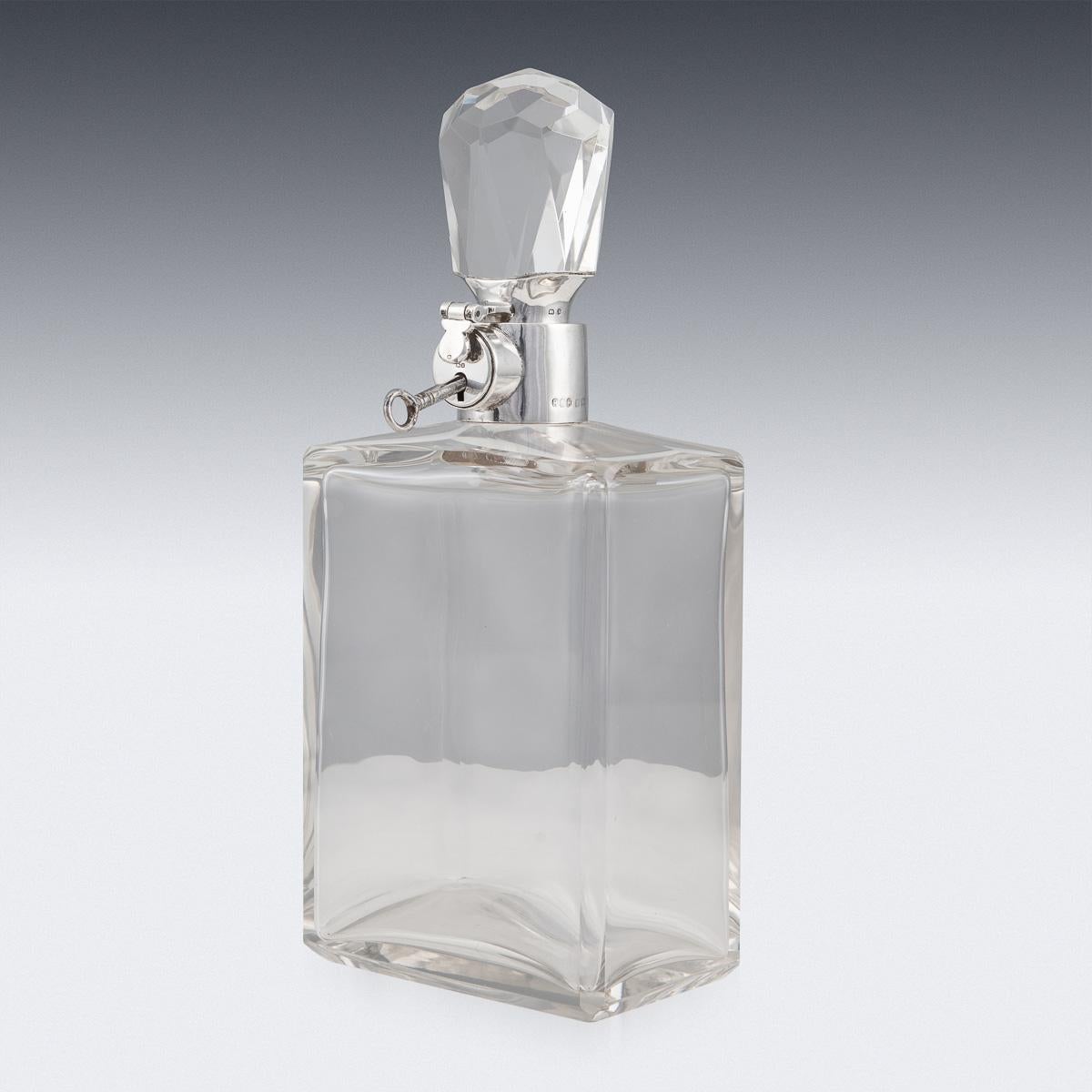 Élégante carafe à alcool Art Déco anglaise du début du 20e siècle en argent massif et verre. De grande taille avec un corps en verre et monté avec un élégant bouchon octogonal coupé. Appliqué avec un collier en argent et un mécanisme de verrouillage