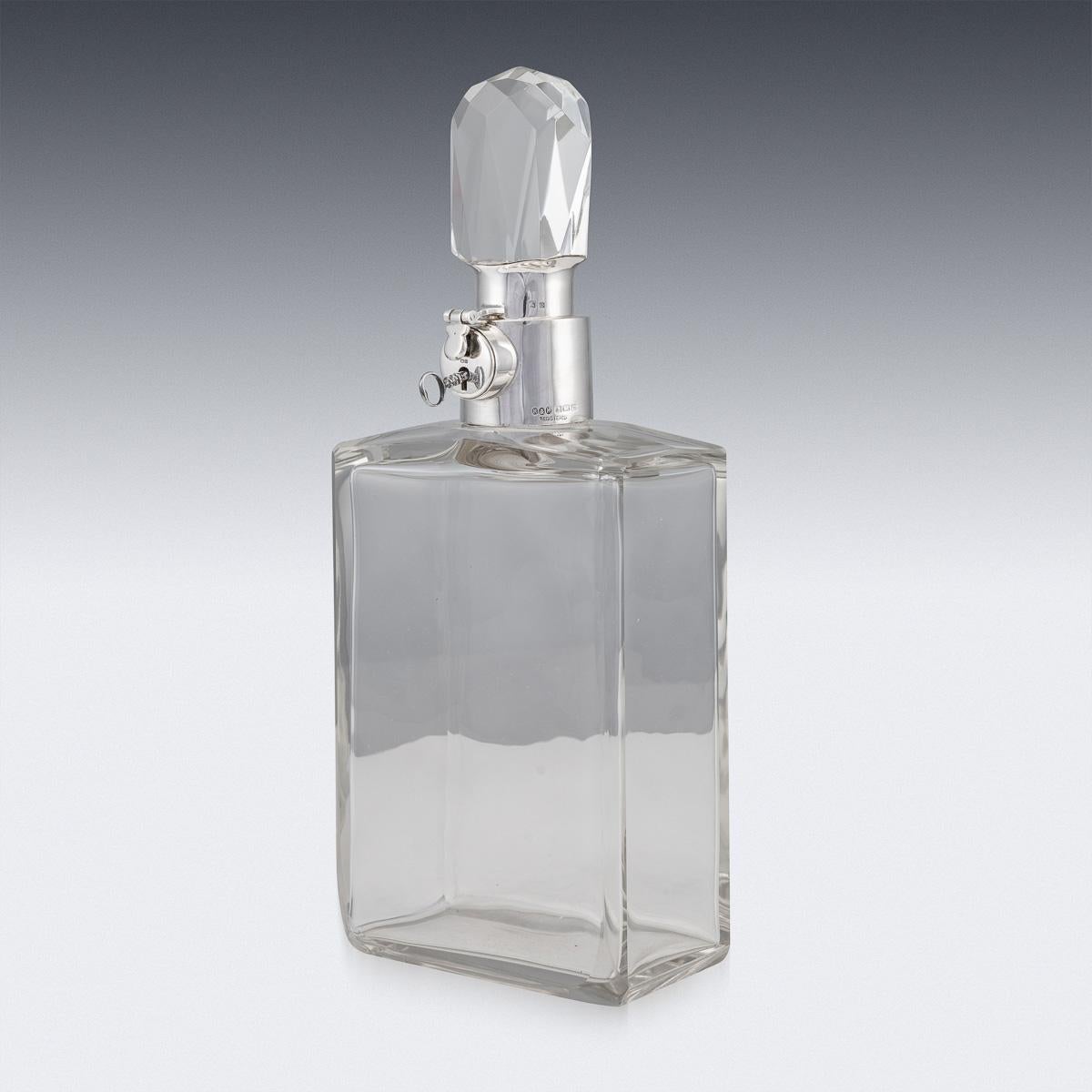 Stylish early-20th century English Art Deco solid silver and glass large spirit decanter. Of particularly large size with glass body and mounted with elegant octagonal cut stopper. Applied with a silver collar and lock mechanism with key. Hallmarked