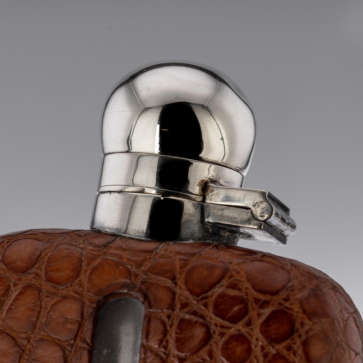 A superb 20th Century solid silver, blown glass and bound in sumptuous crocodile leather hip flask, of rounded rectangular form, with a pull off cup, top mounted with a large hinged lid. Hallmarked with English silver (925 standard), Sheffield, year