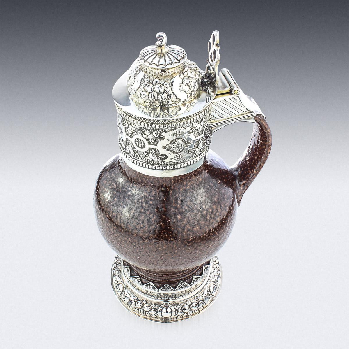 Antique 20th century English solid silver mounted on tigerware pottery wine jug, made in the style of the original Elizabeth I example, highly chased and gilt throughout. Hallmarked English silver (925 standard), Birmingham, year 1919 (u), Maker