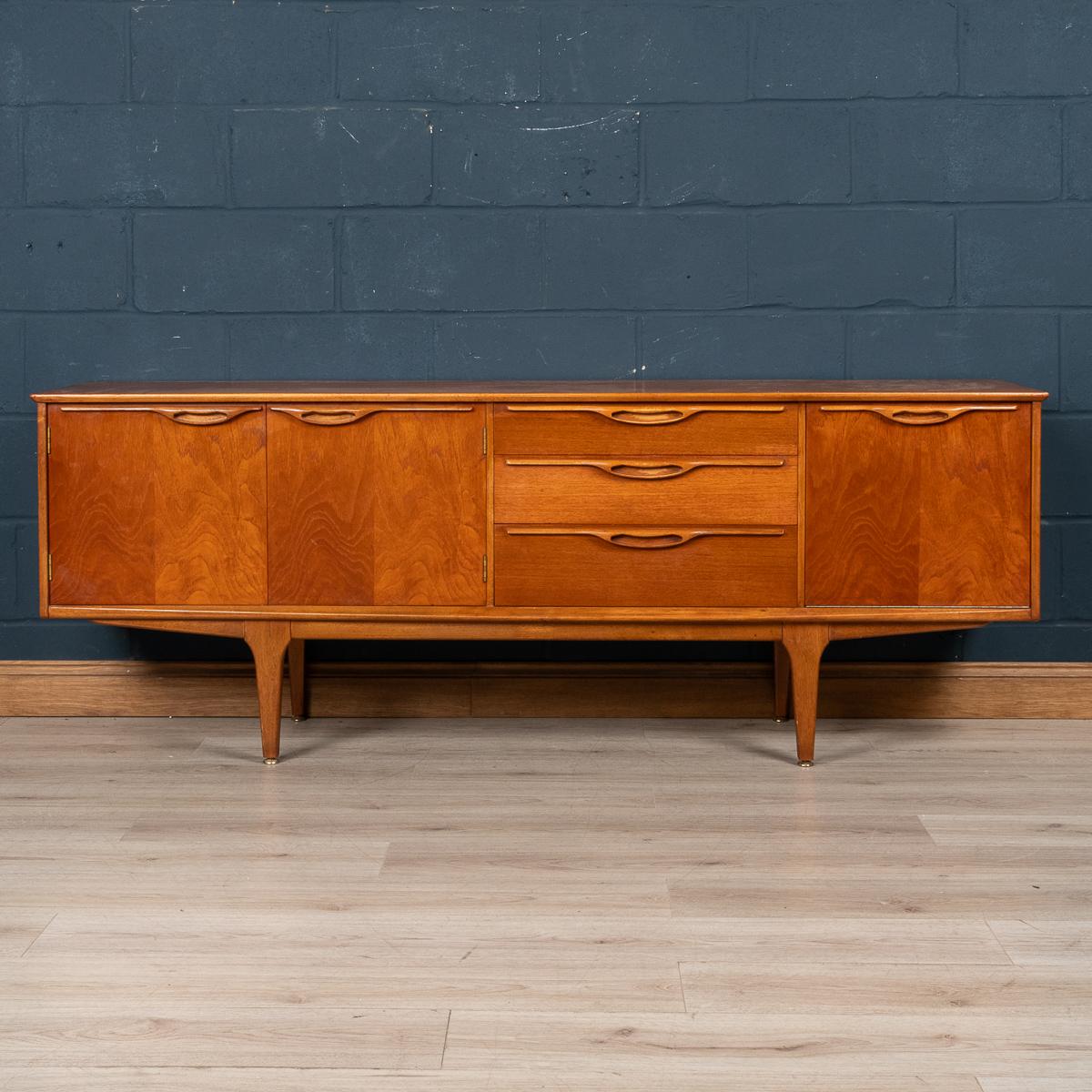A mid 20th Century beautiful English sideboard. Realised entirely in teak wood as was very fashionable in the 1960's these sideboards have had a resurgence in popularity in the modern era as mid century furniture takes pride of place, mixing the new