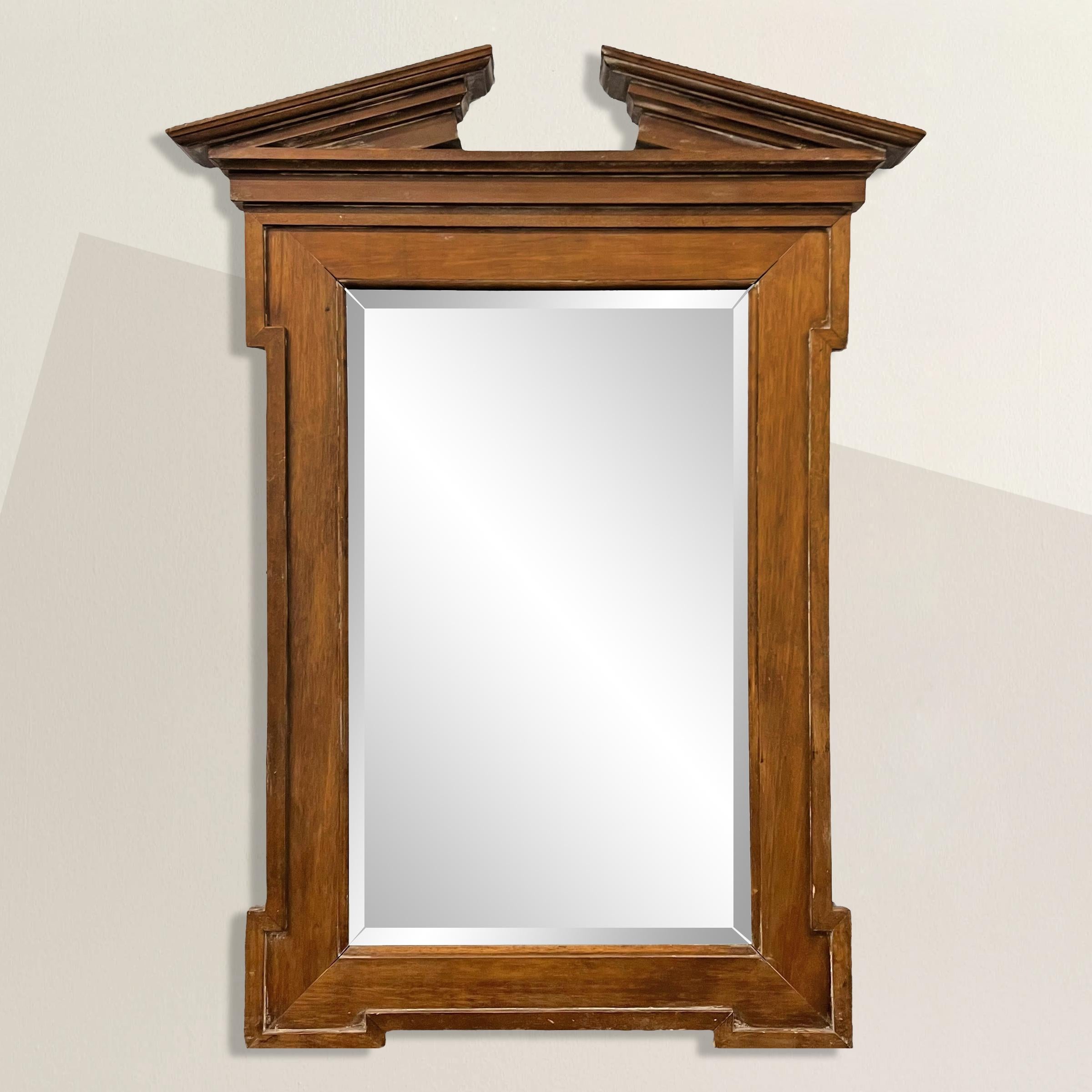 Elevate your interior with timeless elegance using this English Georgian-Style walnut framed mirror featuring a broken pediment inspired by classical architecture. Its wide frame, accentuated by wider square corners, exudes sophistication and
