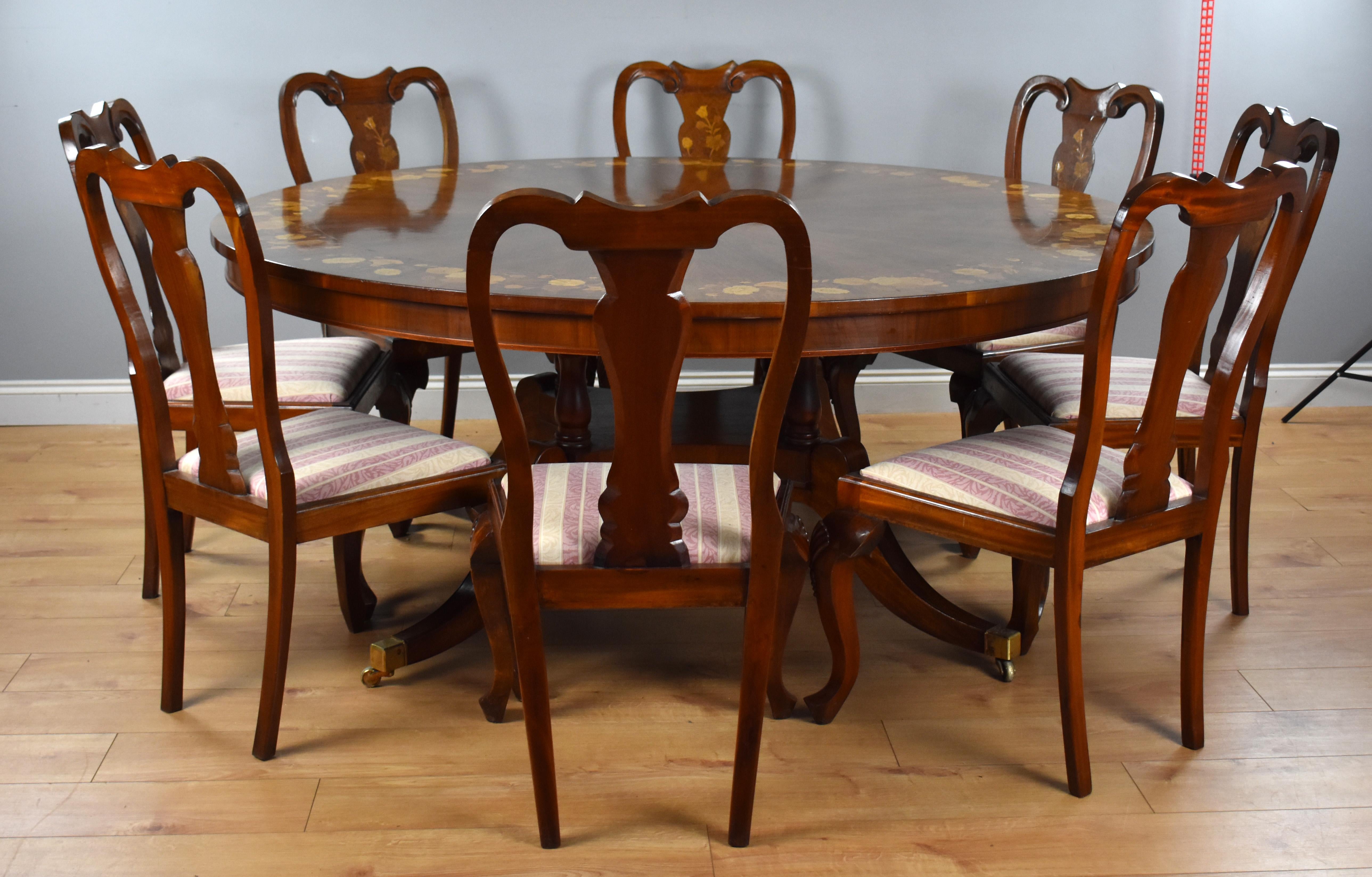 A good quality large circular walnut and marquetry dining table with a set of 8 matching marquetry dining chairs. The table top having radial walnut veneers, nicely inlaid with floral marquetry to the edge as well a central panel, above turned