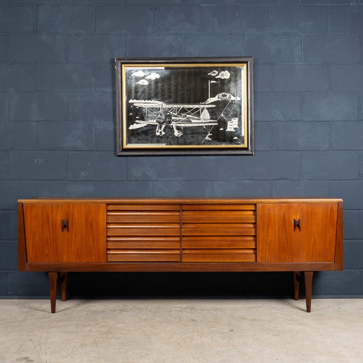 A wonderful and very rare mid century sideboard, made in England around the 1960s. The rarity is in the detail and it shows British cabinetmaking at its finest and most adventurous. The sideboard is made out of walnut and features cool sculpted wood