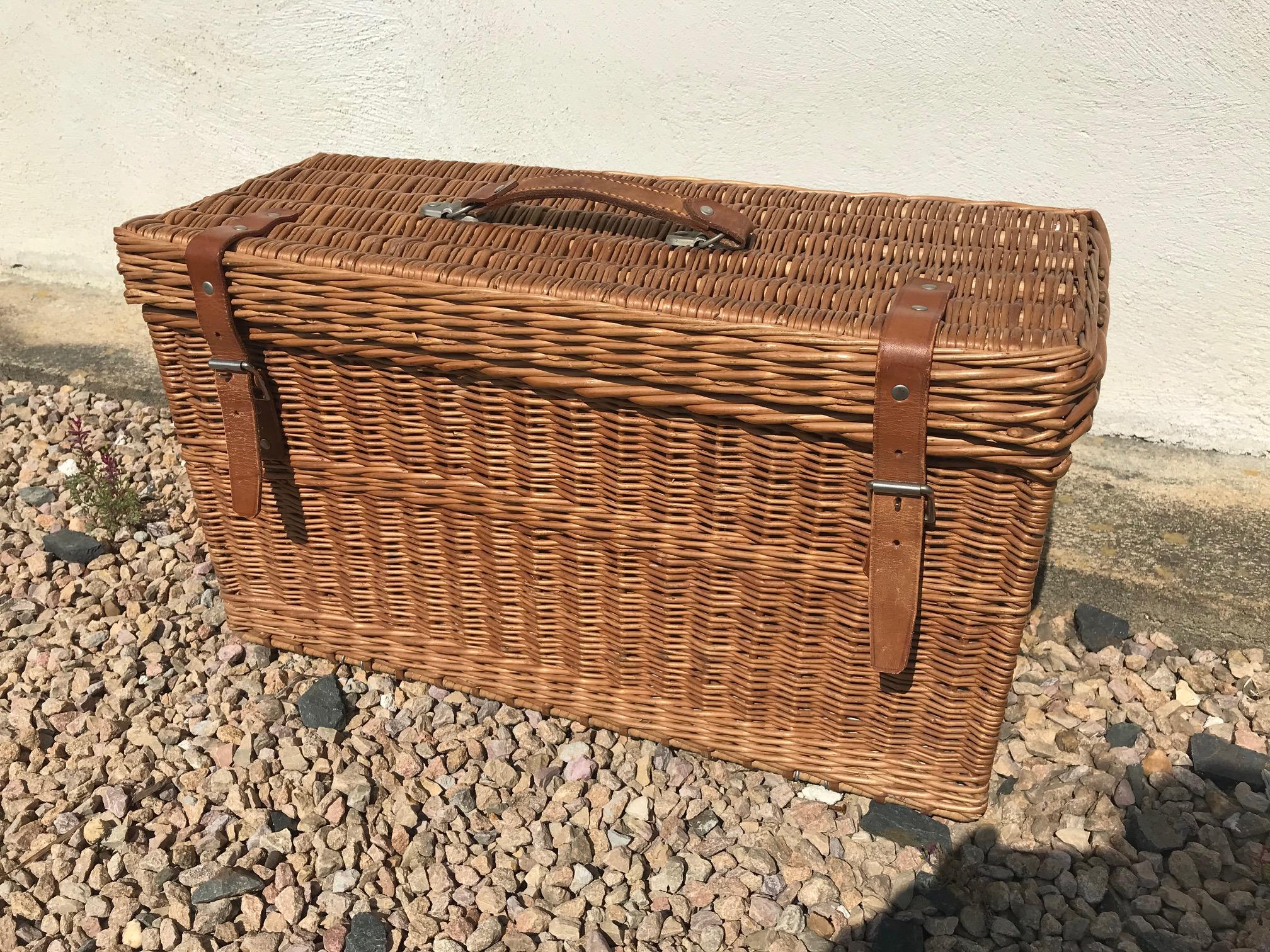 Nice and rare 20th century English wicker picnic basket for four people from the 1950s.
Made by Coracle. Was sold at Harrod's in London.
Four spoons, forks and knives.
Plastic plates, mugs, glass, Tupperware, bottles and one glass carafe. Also