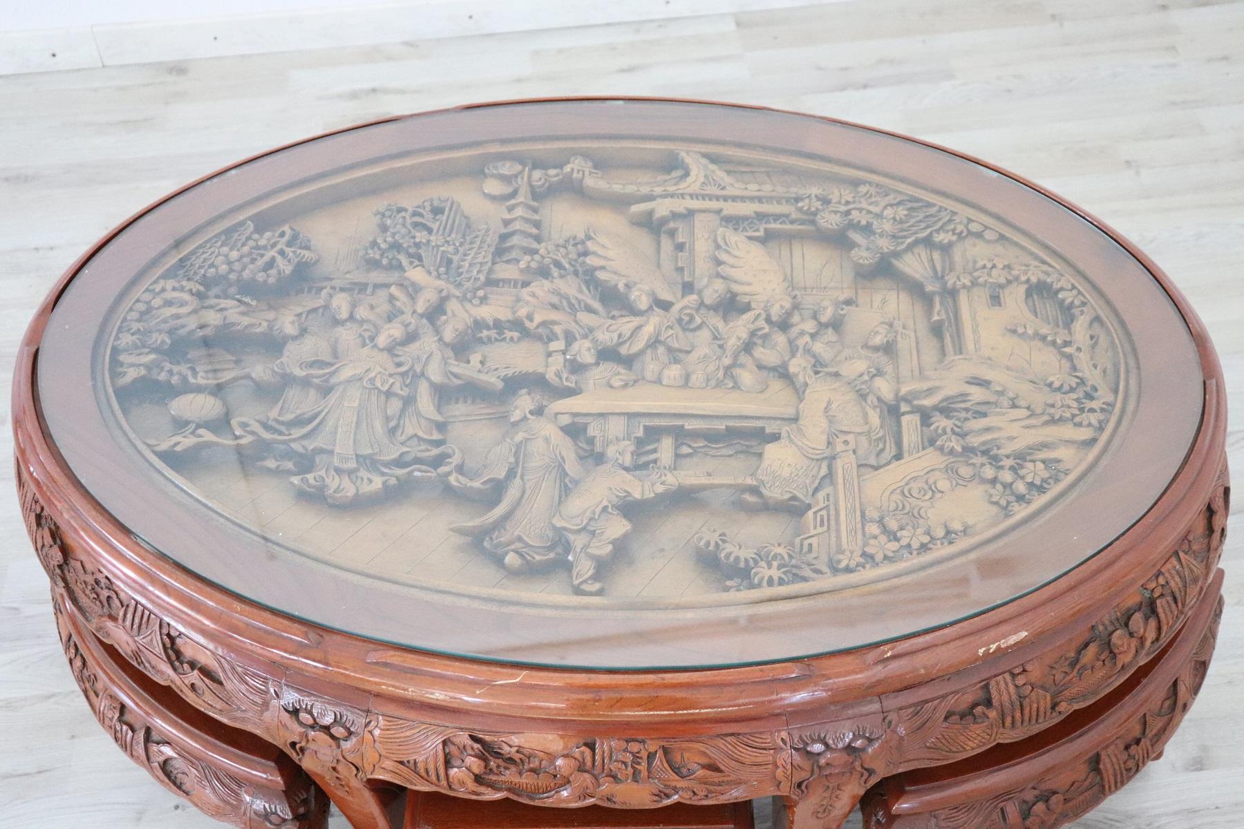 Set of English coffee table from the 20th century with six stool. Beautiful furniture in wood carved decorations. The plan is a spectacular carving with figures and oriental figures in relief. Set consisting of table with glass tops, six stools.