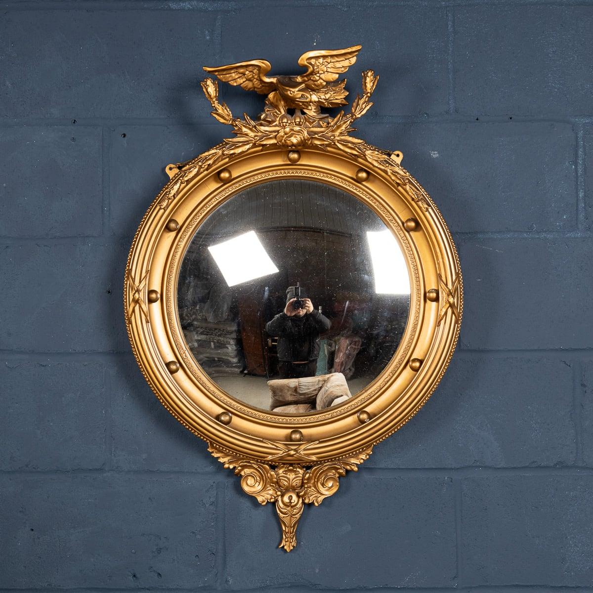 A mid 20th century convex mirror in wood and plaster. Convex mirrors played an important role in the running of the Regency household. Often placed in the dining room, the convex mirror allowed the butler to oversee the progress of supper, whilst