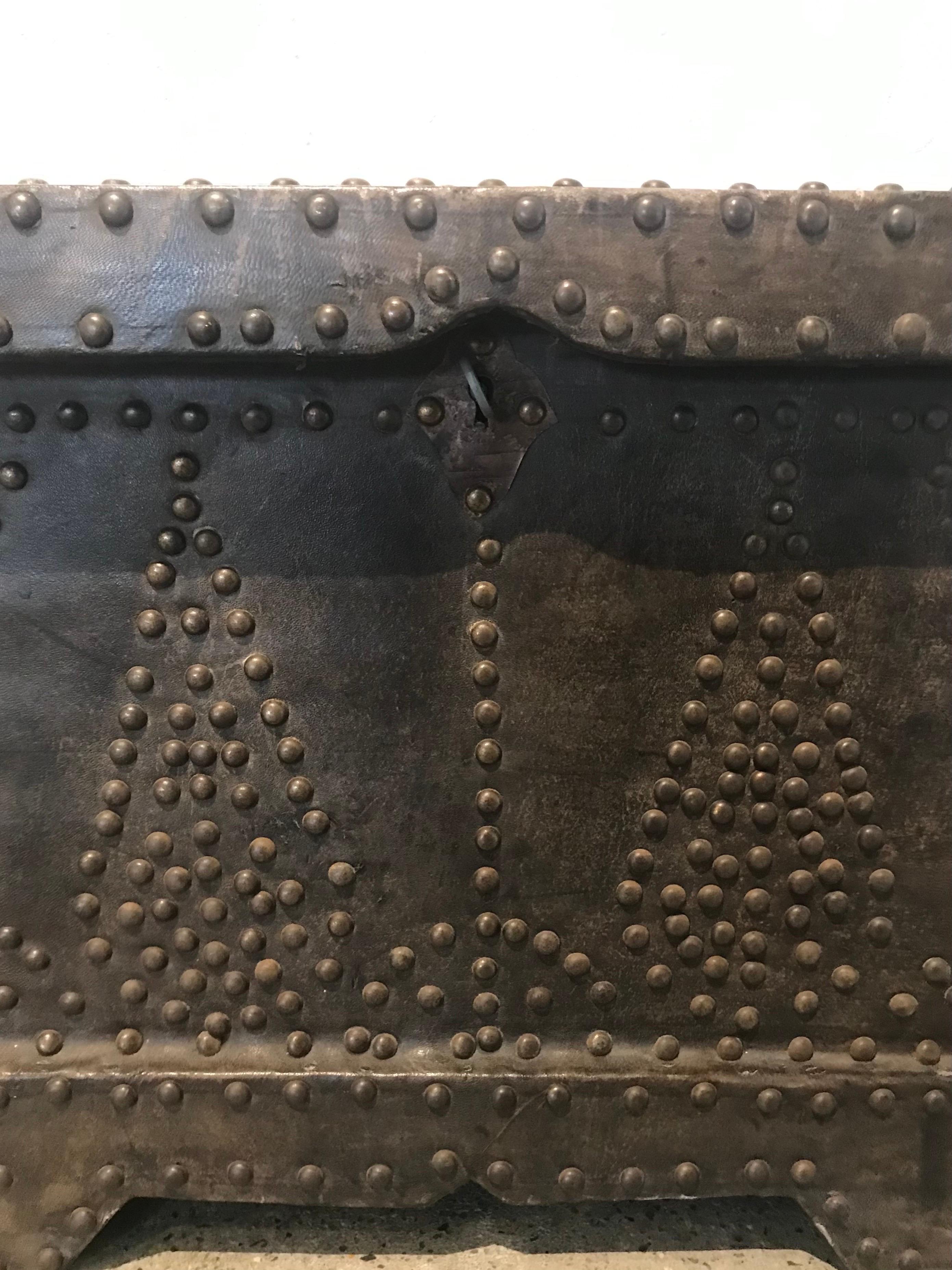 Handsome leather studded trunk with antique brass nailheads in a lovely motif.  Works well as a side table or object d'art.