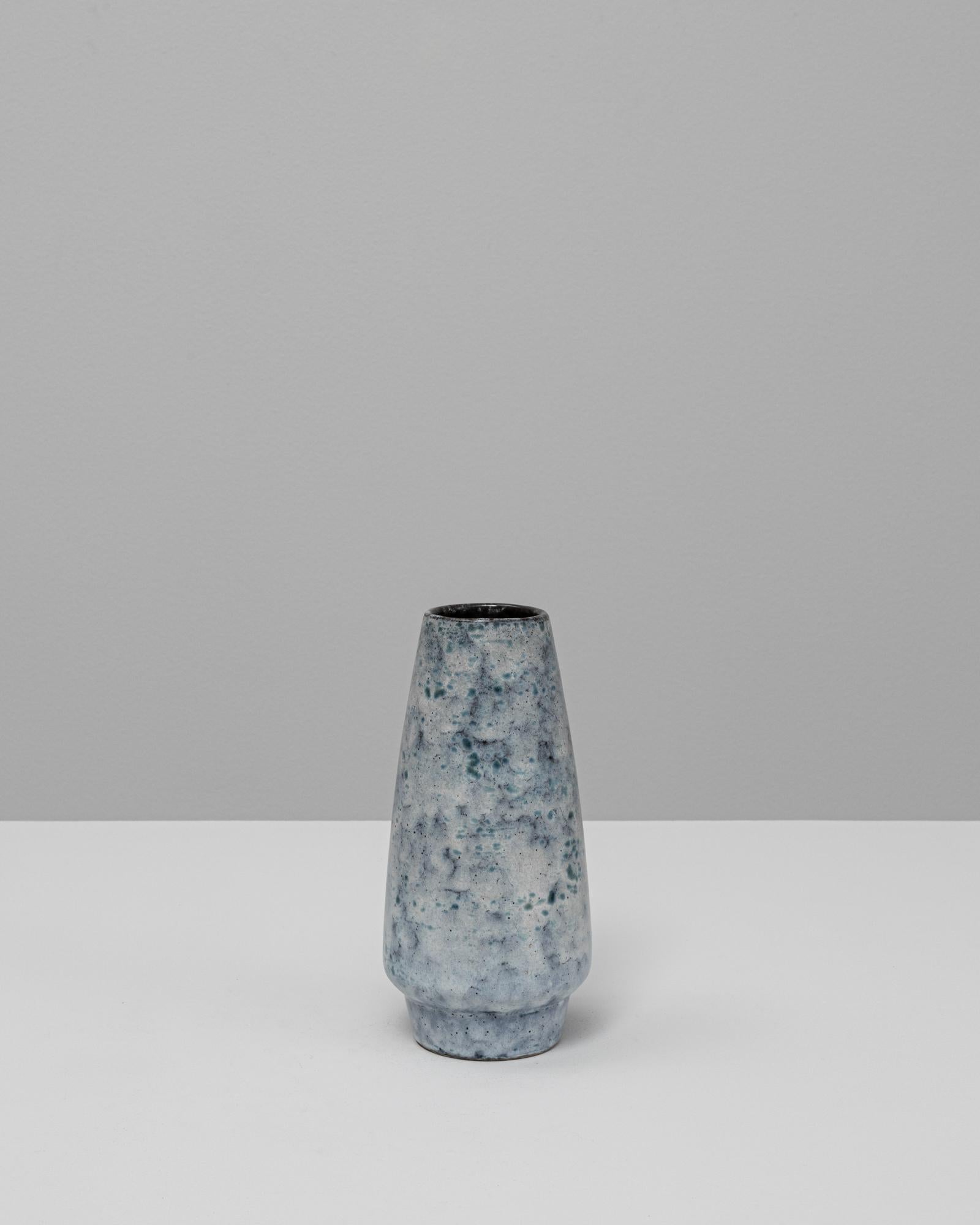 Questo vaso in ceramica del XX secolo presenta una silhouette raffinata e affusolata, abbinata a uno smalto ricco di atmosfera che cattura l'essenza dell'estetica della lava grassa in un'interpretazione più sottile e contemporanea. La superficie è