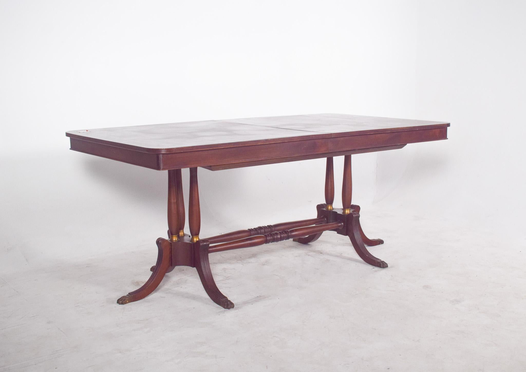 Table de salle à manger rectangulaire extensible. D'inspiration classique, il présente une structure robuste et des lignes élégantes. Le plateau rectangulaire a des coins légèrement arrondis et est divisé au centre pour permettre l'installation