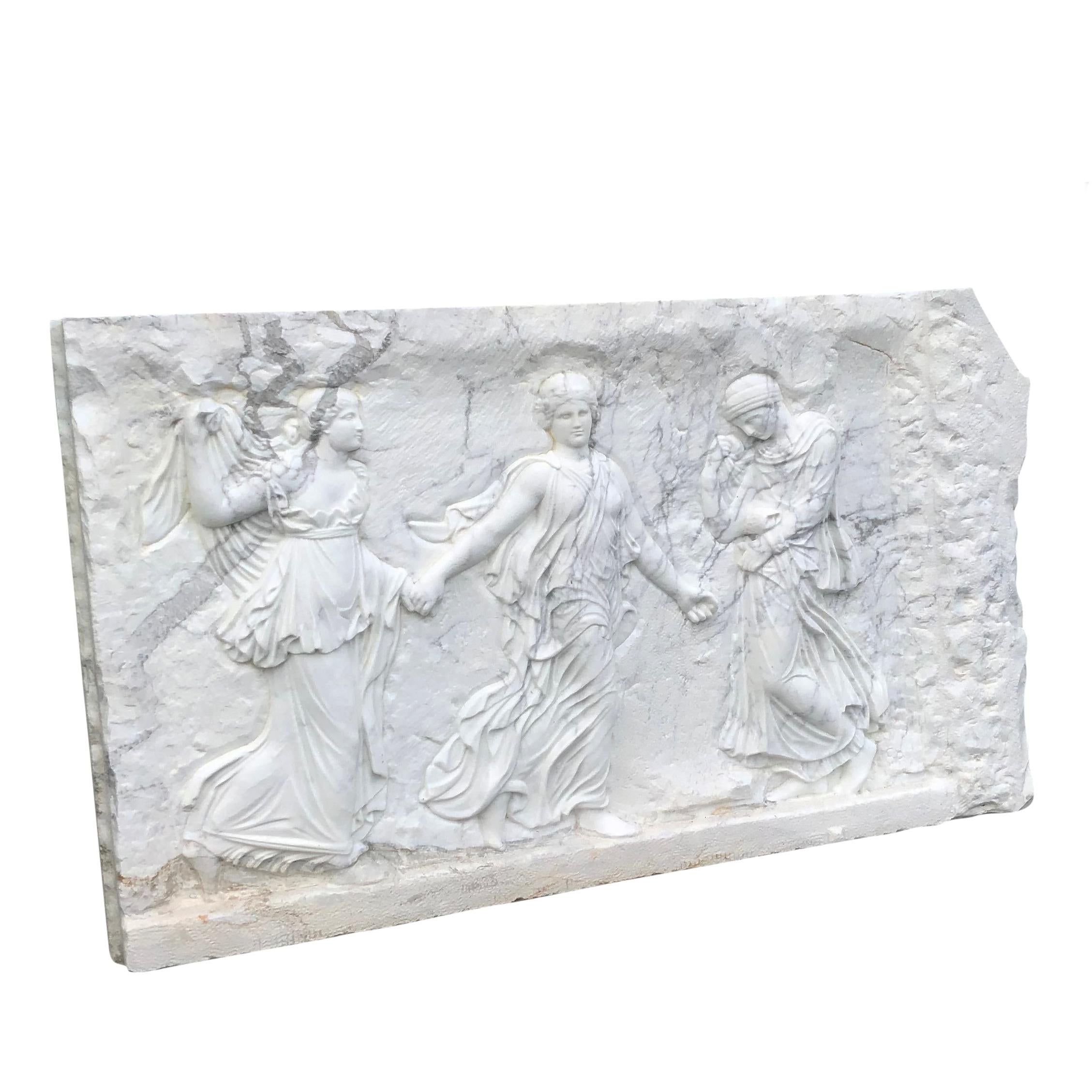 An antique wall relief in white Statuario marble of rectangular shape, depicting the Three Graces, in good condition. They were goddesses originated from Greek mythology and personified charm, grace, and beauty.  They were associated with Aphrodite