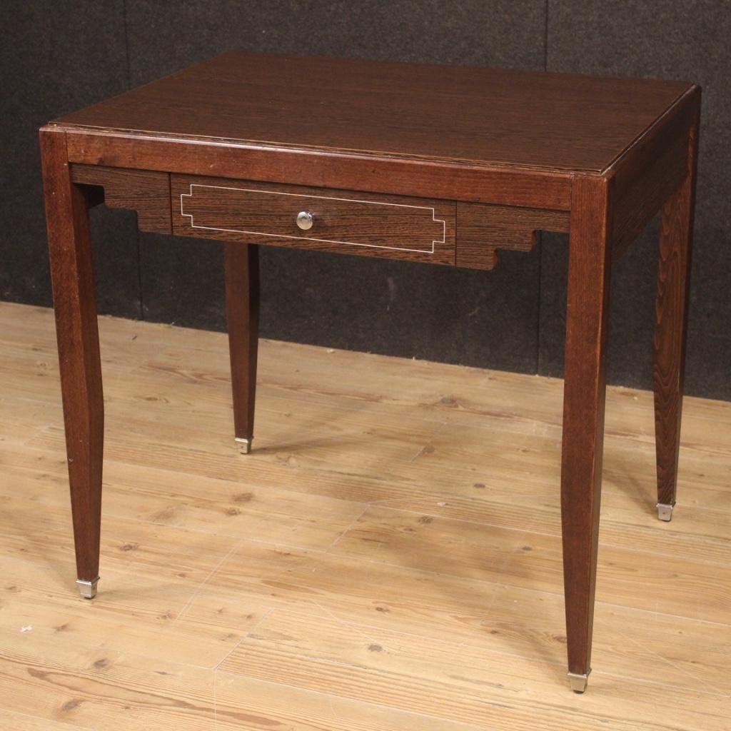 Small French writing desk from the 1980s. Particularly designed and built furniture, of French design, in exotic wood with palisander finishes. Desk finished for the center and fitted with a front drawer. Silver metal knob and feet (see photo).