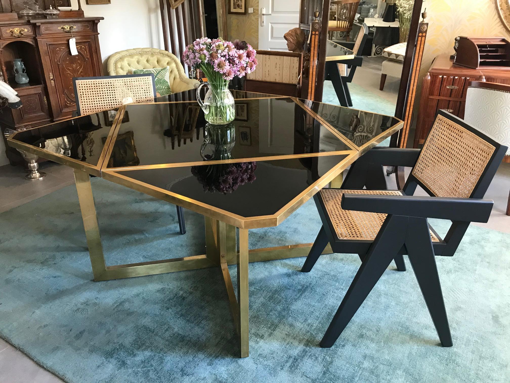 Beautiful and inventive table designed by the Italian Romeo Rega made with brass and black lacquer from the 1970s.
High quality materials, gilted brass cross structure and black lacquer top.
This square table is folding in four parts, either for
