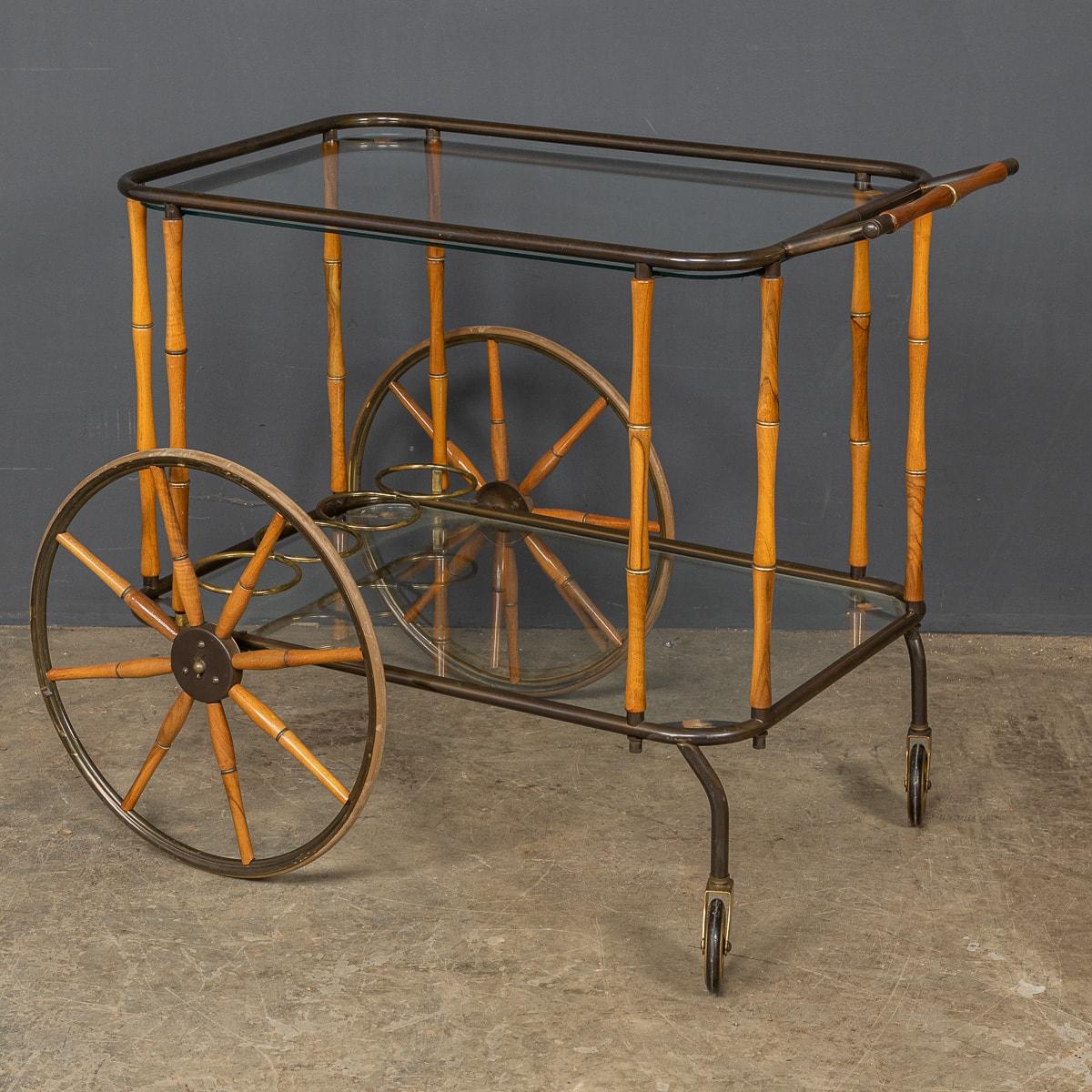 A rare 20th century bar cart attributed to Maison Jansen, this practical piece has two glass trays, the lower tray with original bottle holders, two large wheels and two small.

CONDITION
In Great Condition - wear consistent with age, please