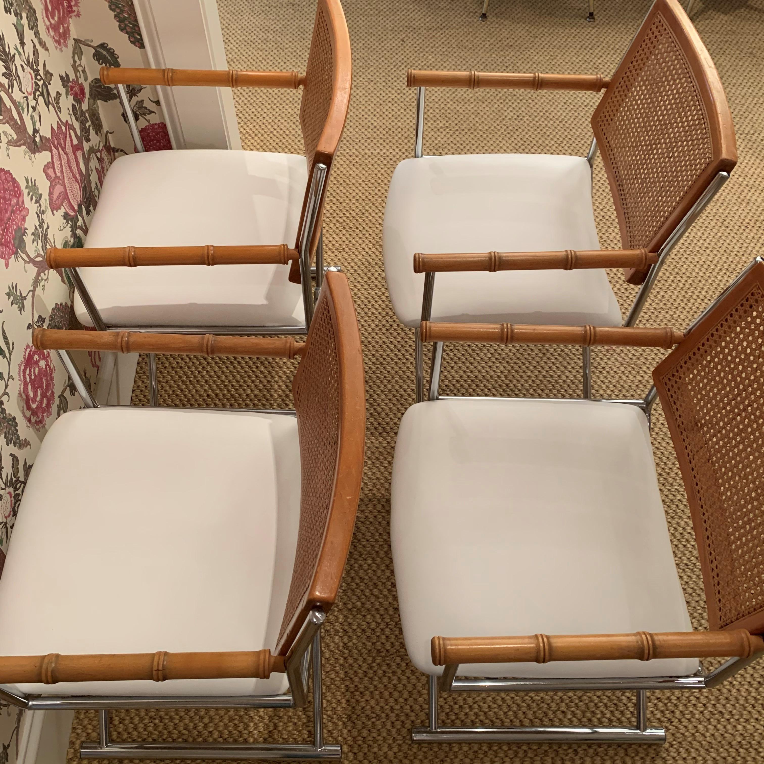 Set of 4 midcentury faux bamboo chrome directors chairs upholstered with newly upholstered white leather seats and back rest of 100% cane.
 