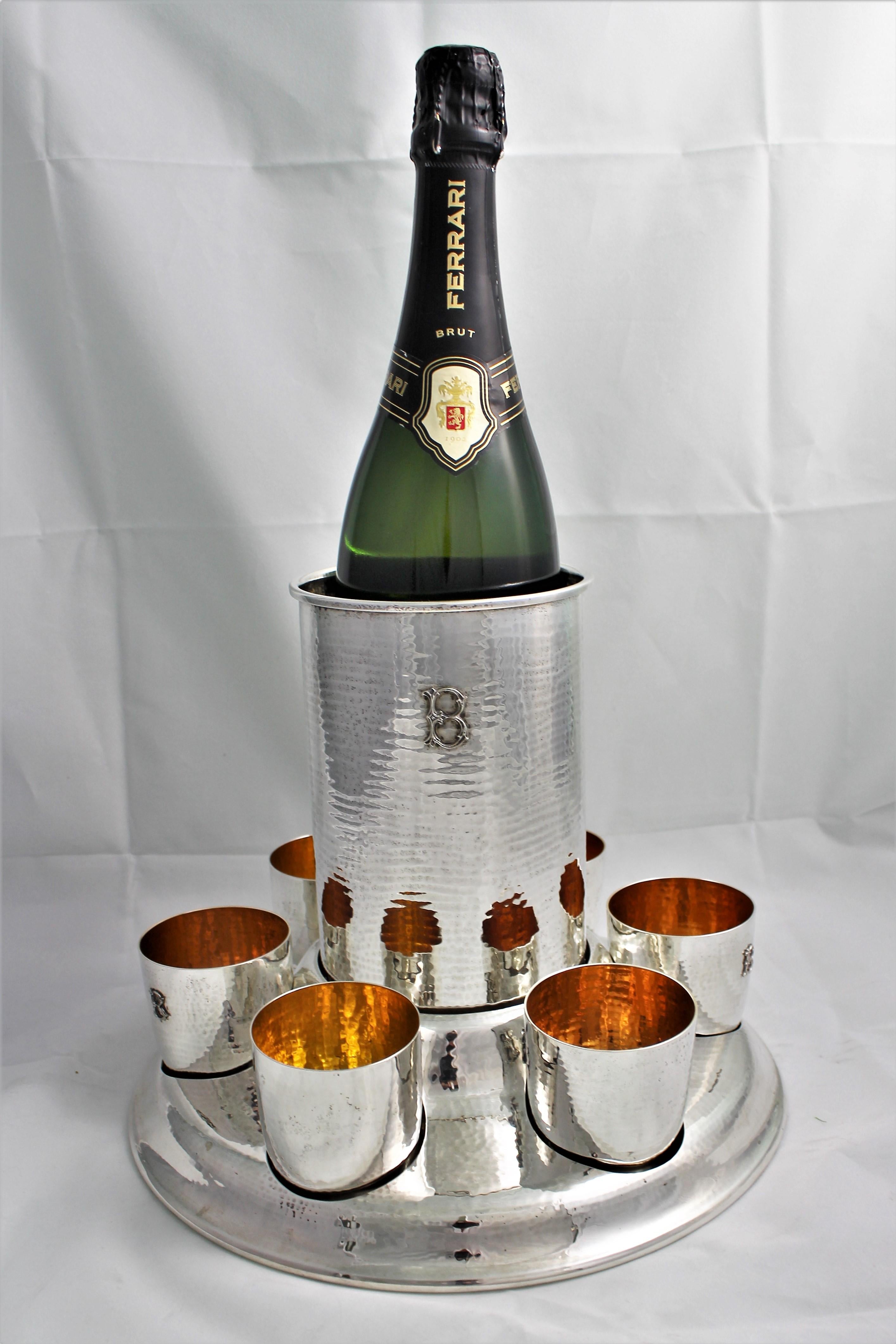 Wonderful sterling silver set by Federico Buccellati.

Composed by base, wine cooler and 6 glasses. 

The wine cooler fits in the base in apposite lodging, same happens for the glasses.

Sterling silver hammered by hand. The wine cooler and