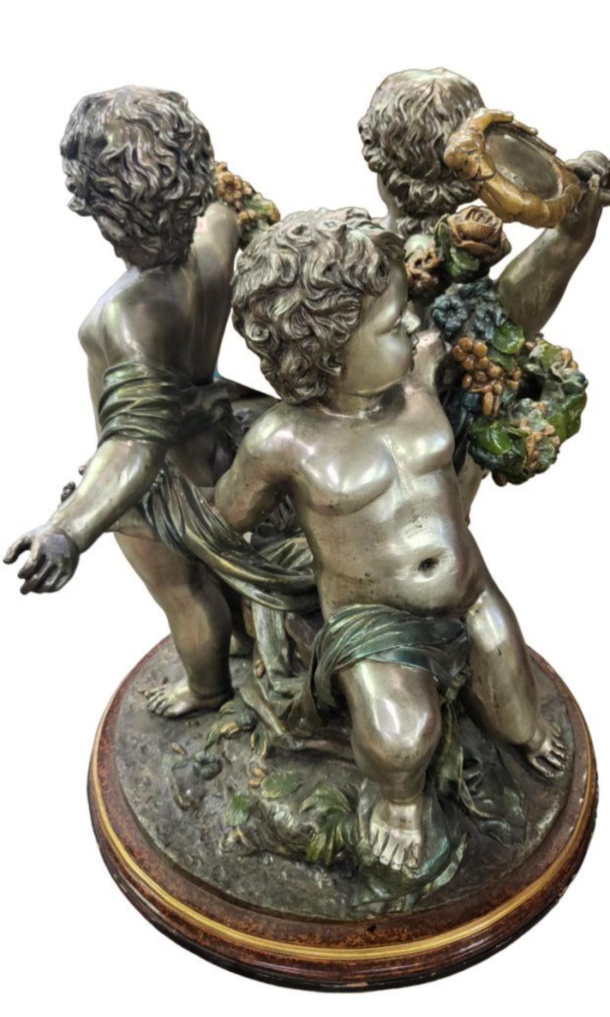 S. Kelliam (20th Century) Figural bronze group of cherubs. Depicting seated cherubs on a rock, signed S.Kelliam. Patinated and silver-gilt bronze. The glass top is not shown in the picture.