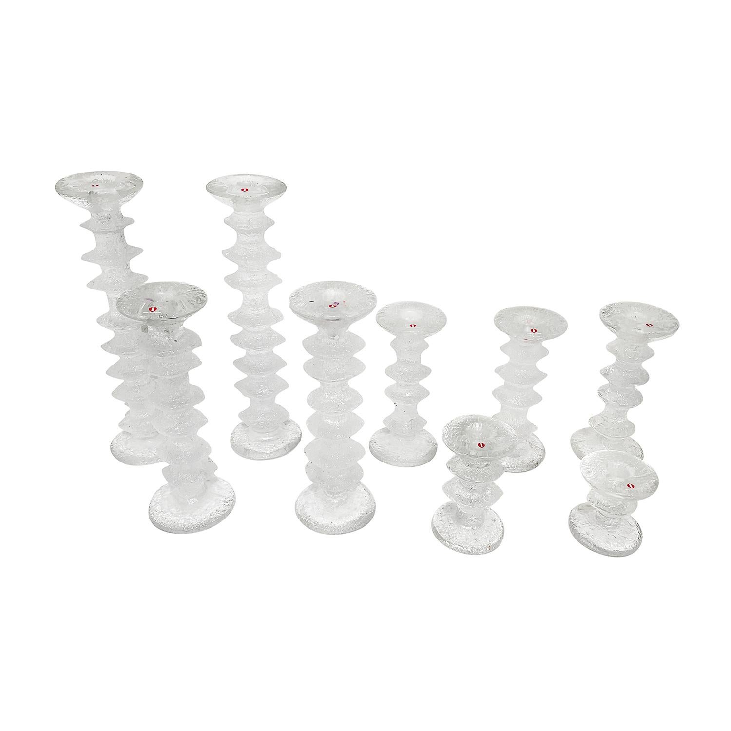 A slightly smoked, vintage Mid-Century Modern finnish set of nine Ljusstakar, candlesticks with the original box, made of hand blown molded glass, designed by Timo Sarpaneva and produced by Festivo - Iittala, in good condition. The vintage candle