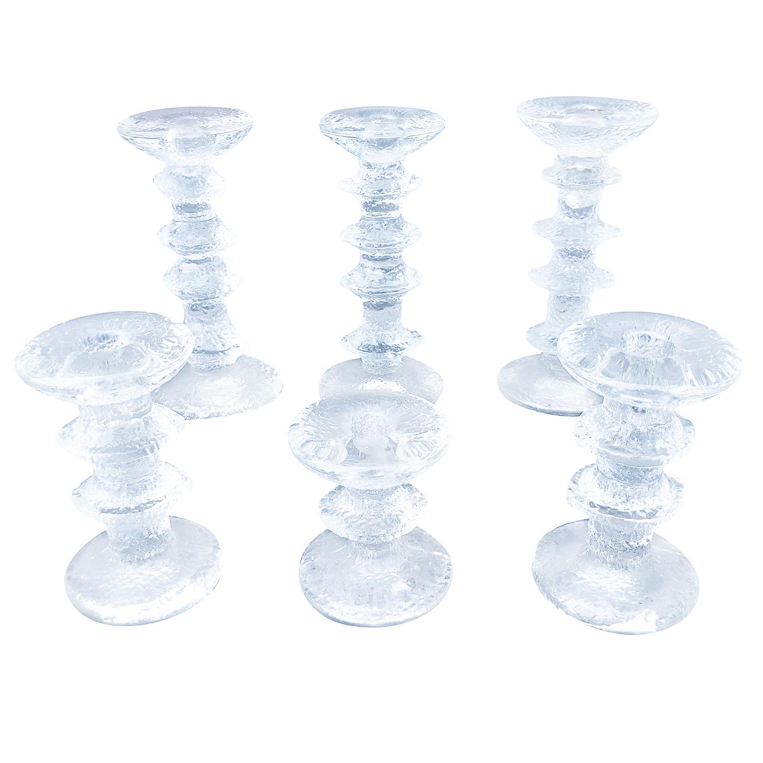 A vintage Mid-Century Modern Finnish set of candlesticks made of molded glass. Produced by Festivo - Iittala, designed by Timo Sarpaneva in good condition. The vintage candleholders come in a variety of sizes which creates an astonishing display