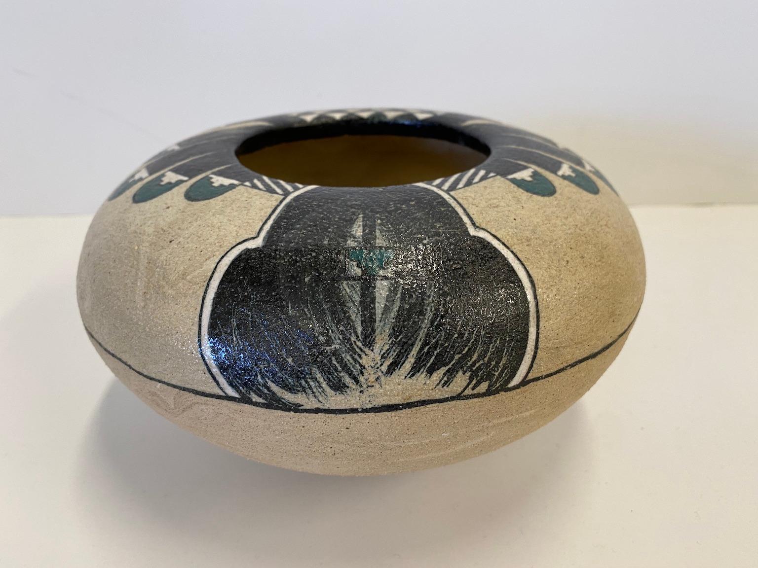 This is a fired and glazed clay pot, painted with a Native American inspired design, circa 1988, by American artist Gary Dale Campbell (1938-2002).