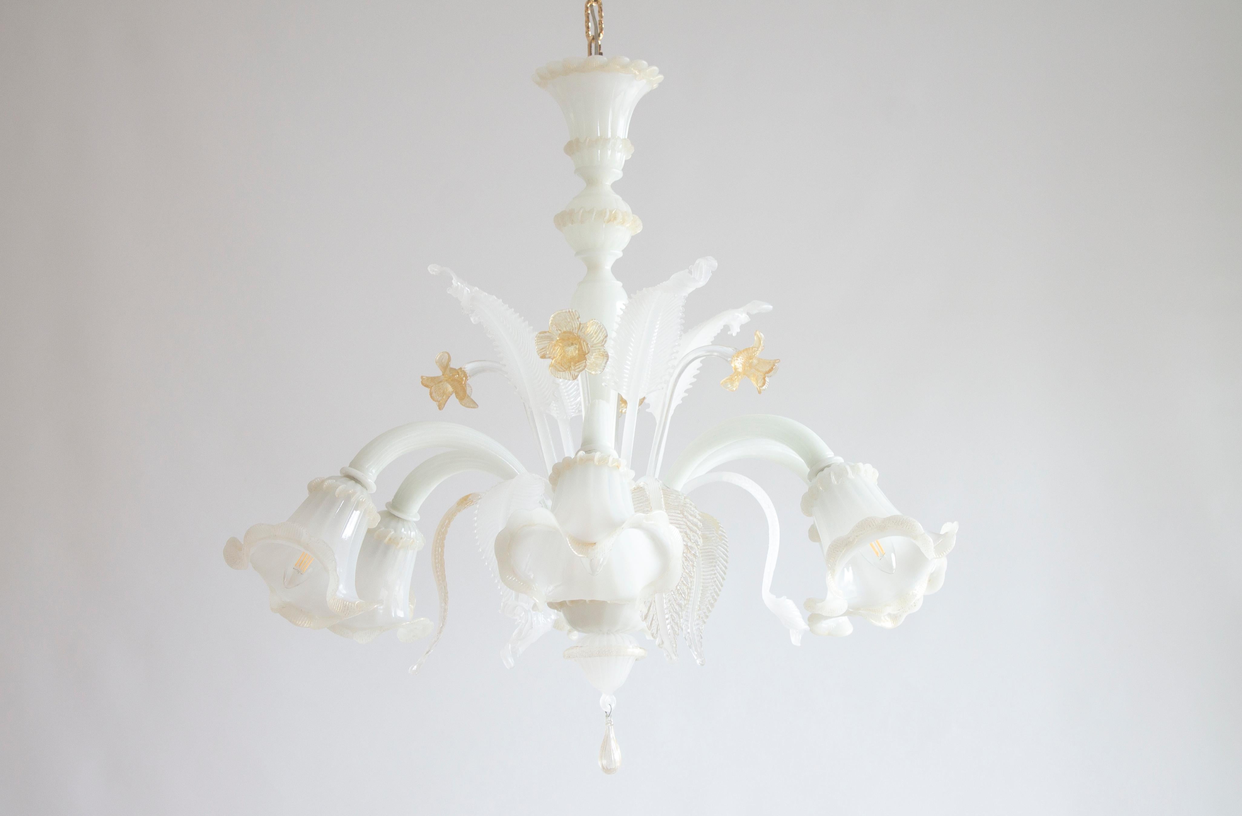 Elegant 20th century floral chandelier in silk-and-amber-colored Murano glass, with gold finishes, Italy.
This refined chandelier, handcrafted in the Italian island of Murano, stands out for its colorful floral decorations embellished with gold