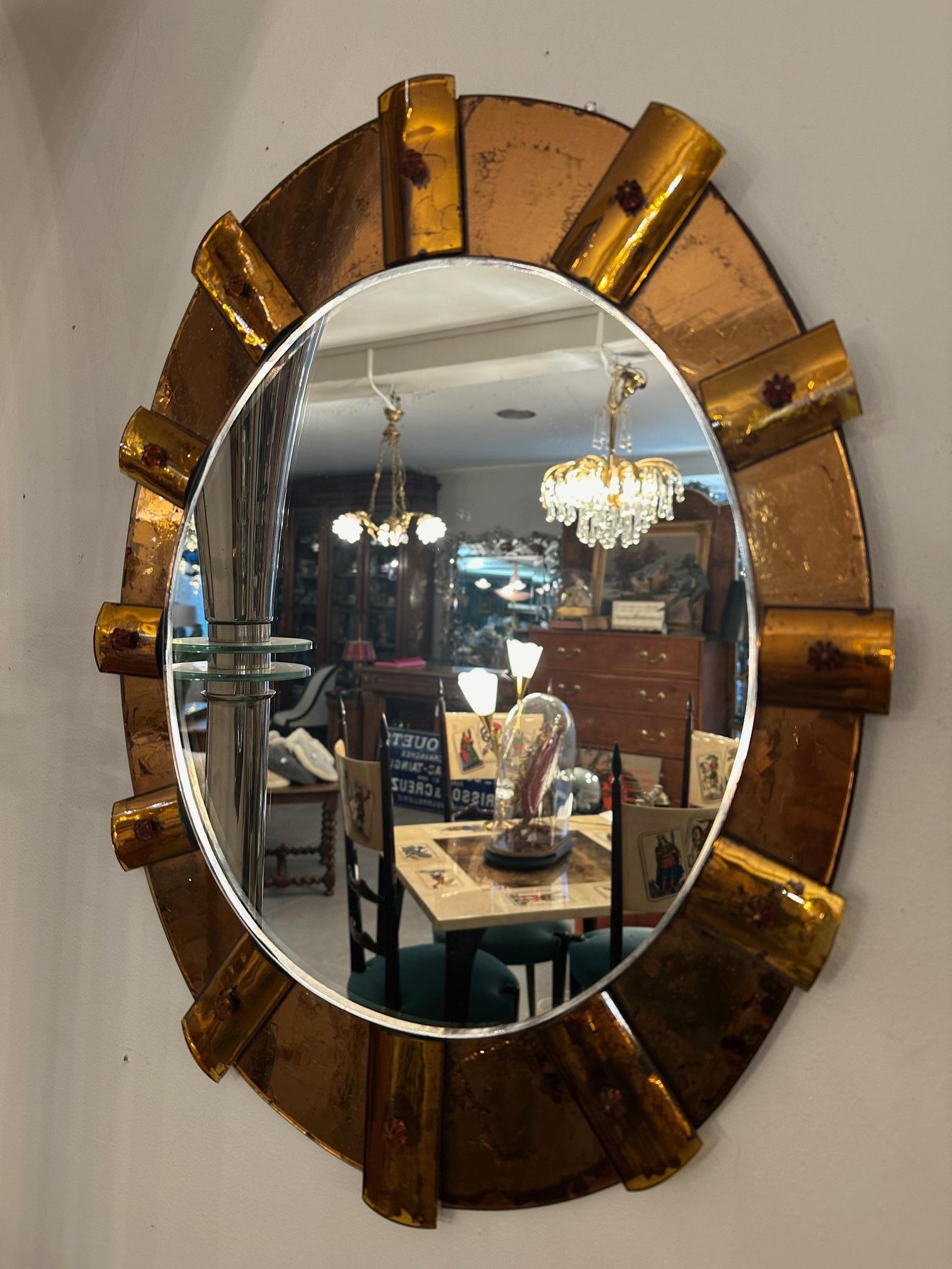 Very beautiful Italian Fontana Arte style mirror from the 60s in good condition.
Oval shape. Double layer mirrors, an oval mirror in amber background with traces of mercury and decorated with pieces of rectangular mirror to give an impression of