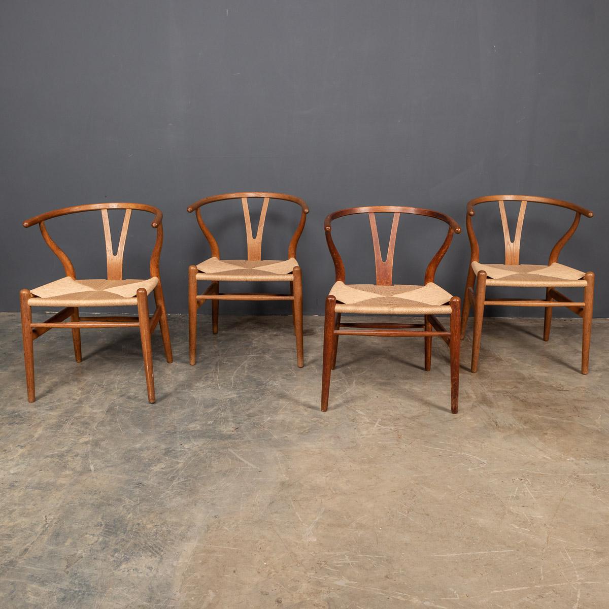 Iconic mid-20th century set of four Wishbone dining chairs, also known as the CH24 Chair or Y Chair is a chair designed by Hans Wegner in 1949 for Carl Hansen & Søn. The chair features a bentwood armrest and a paper cord rope seat in an woven