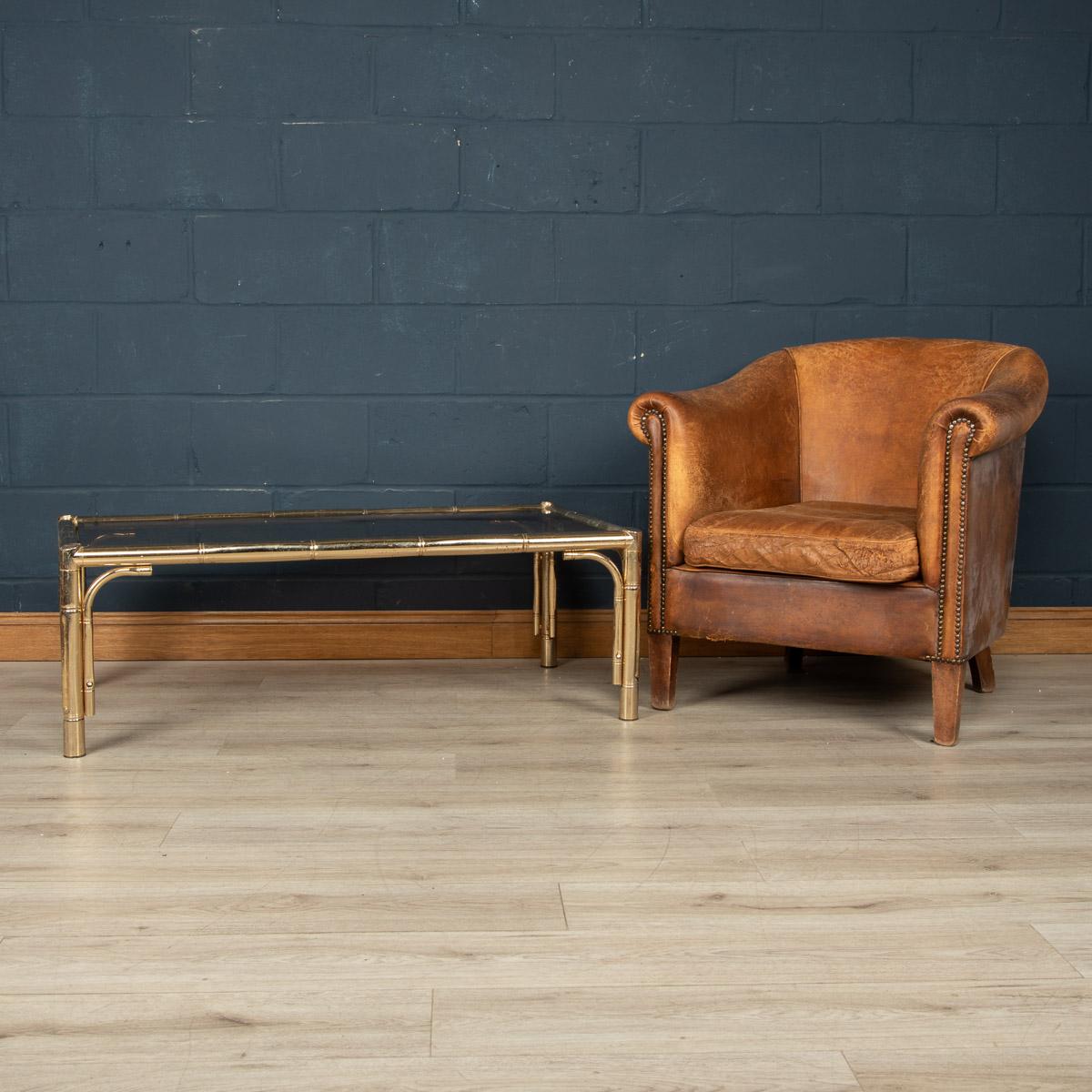 A large coffee table attributed to Maison Jansen, made in France around the 1970s. The faux bamboo frame made out of brass supporting smoked glass. A truly elegant solution for any interior looking to enrich the room with a little vintage class of