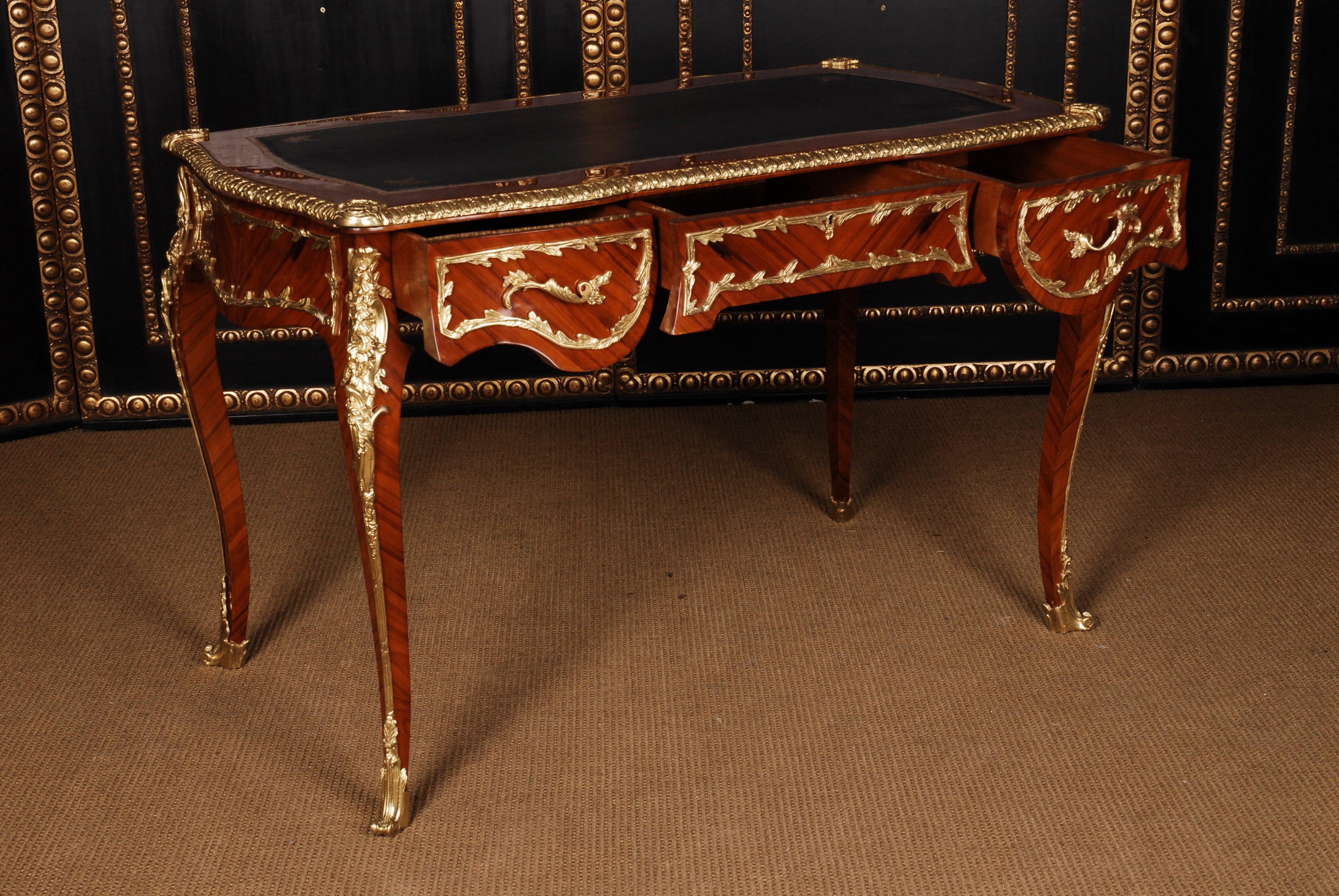 Chapa de madera exótica clara y oscura, sobre la base de cáscara de cuatro lados curvados pasivamente, en escuadras altas y elegantemente curvadas. Tablero ligeramente superpuesto con forro de bronce decorado perfilado e inserto de cuero repujado en