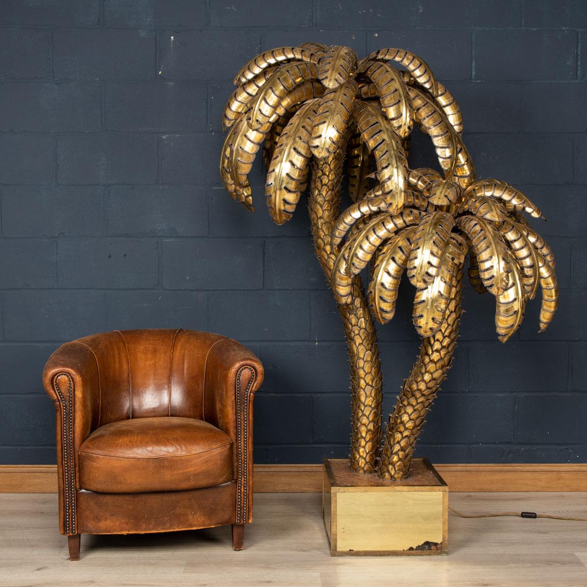 Un grand et très rare lampadaire en forme de palmier de la Maison Jansen datant des années 1960/70, avec deux points lumineux. Les palmes coupées à la main et le tronc sont façonnés à partir de feuilles de laiton qui se chevauchent. De proportions