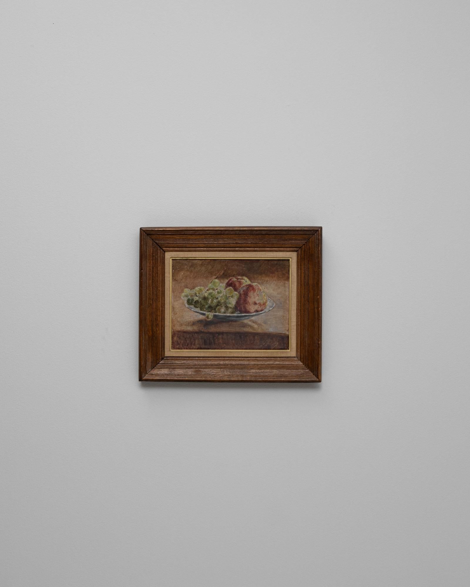 Nature morte en bois du 20e siècle avec cadre en bois. Cette nature morte intime représente une assiette de raisins et de pommes dans des tons doux et terreux, reflétant la beauté tranquille des objets quotidiens. Le pinceau délicat de l'artiste et