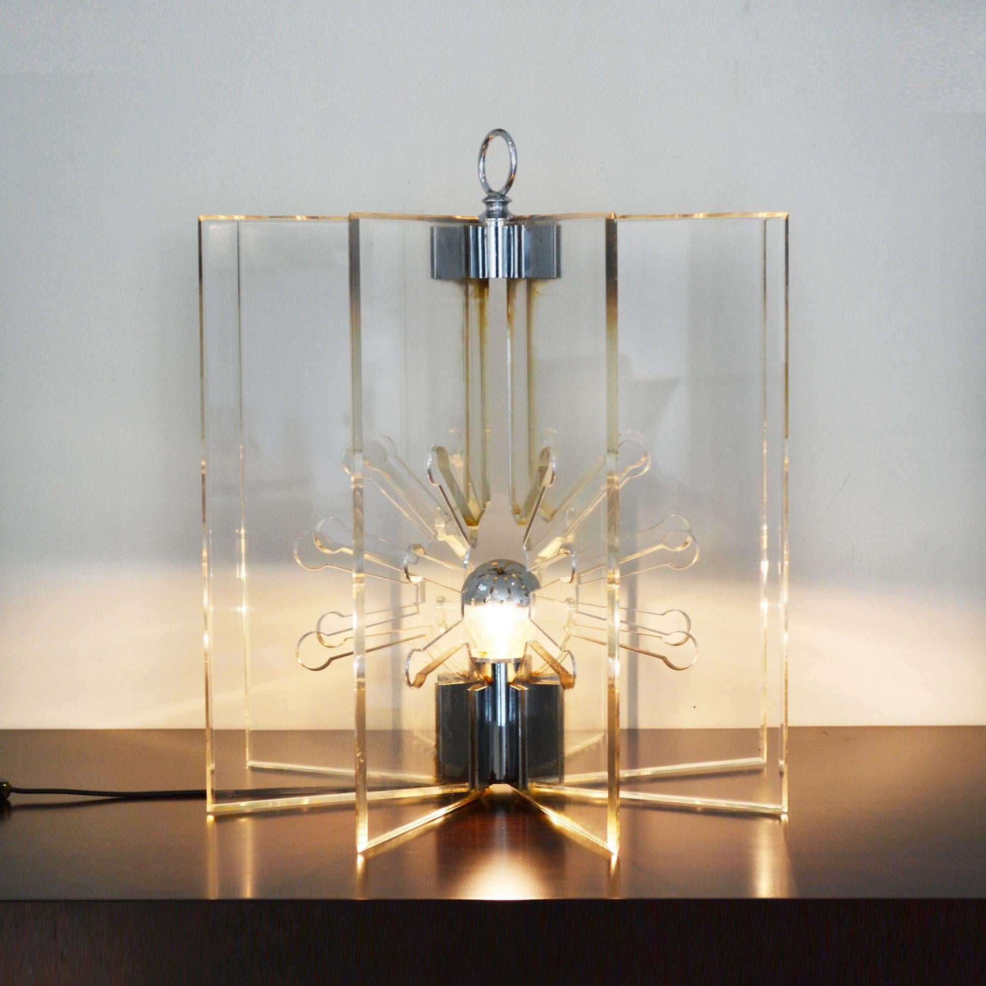 Table lamp model 524 designed by the couple of great designers such as Franco Albini and Franca Helg, produced starting from 1963 for Arteluce. The lamp has a core structure in chromed brass with eight transparent panels in perspex. 
Good
