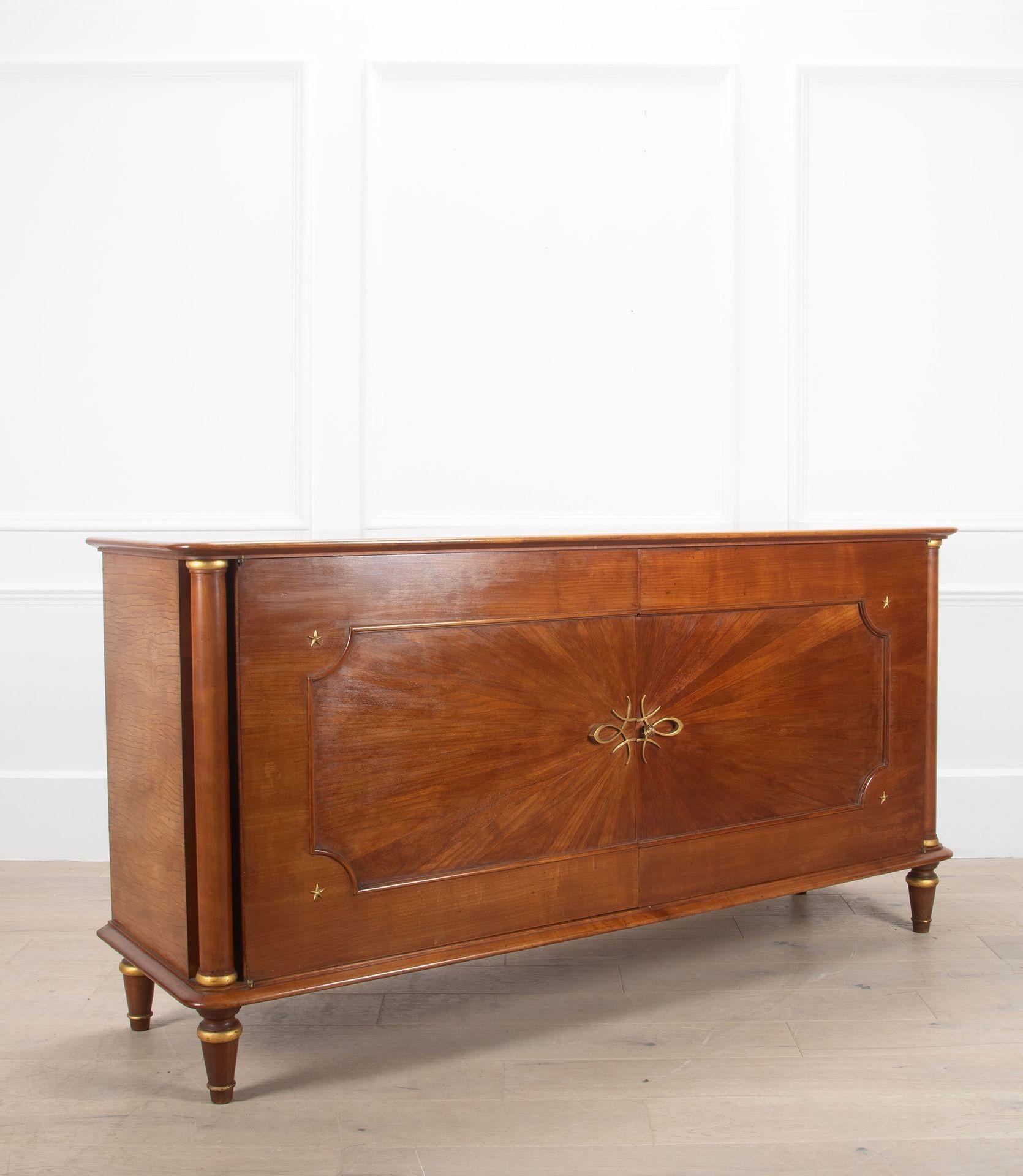 Una credenza francese del XX secolo elegante e di buona qualità.
Con decorazioni in bronzo a volute sulle porte centrali su pannelli impiallacciati a raggiera. Interni impiallacciati in legno chiaro. Con supporti decorativi a colonna su ciascun lato