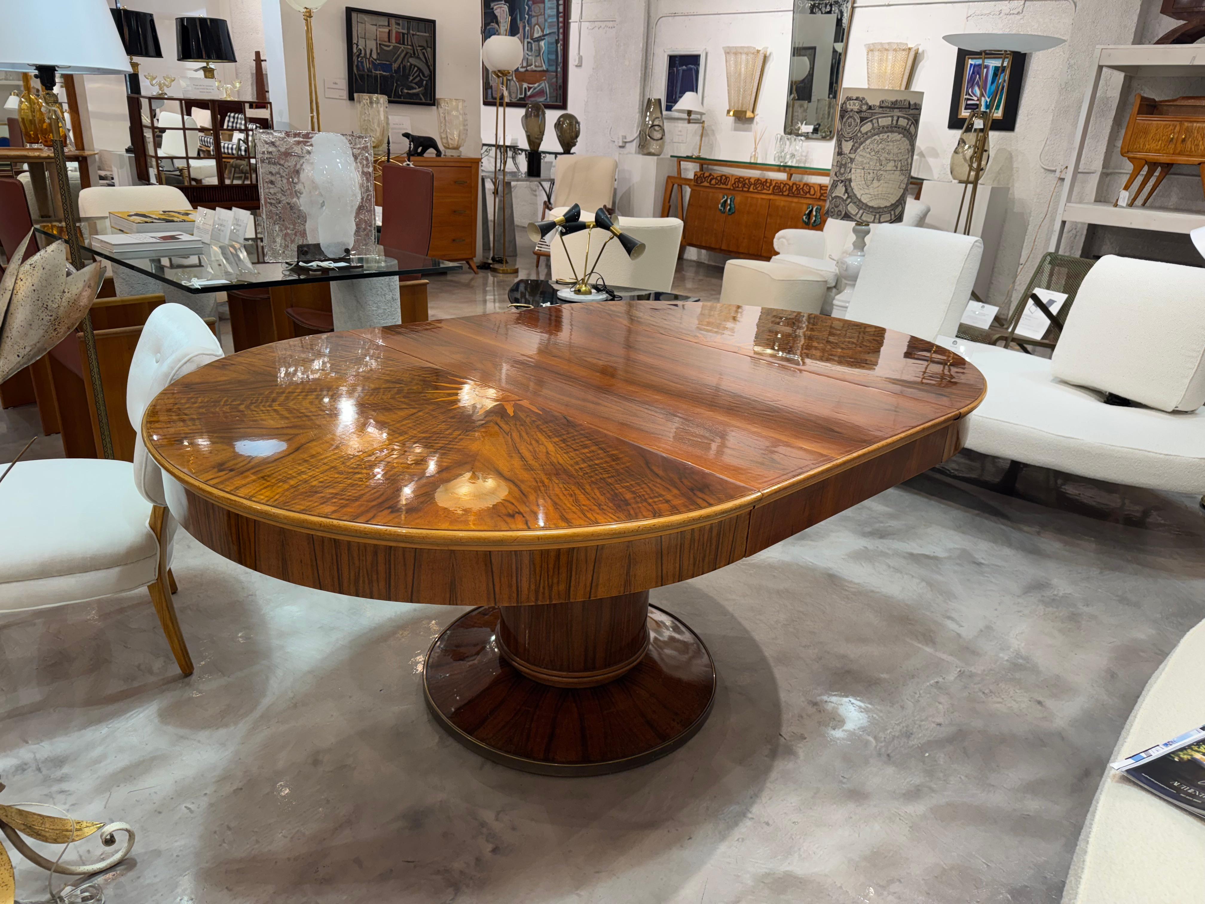 Table de salle à manger Art Deco française du début du 20e siècle, avec un abattant, en noyer partiellement plaqué et poli à la gomme laque, en bon état. La table de conférence coulissante parisienne est soutenue par un large pied rond, reposant sur