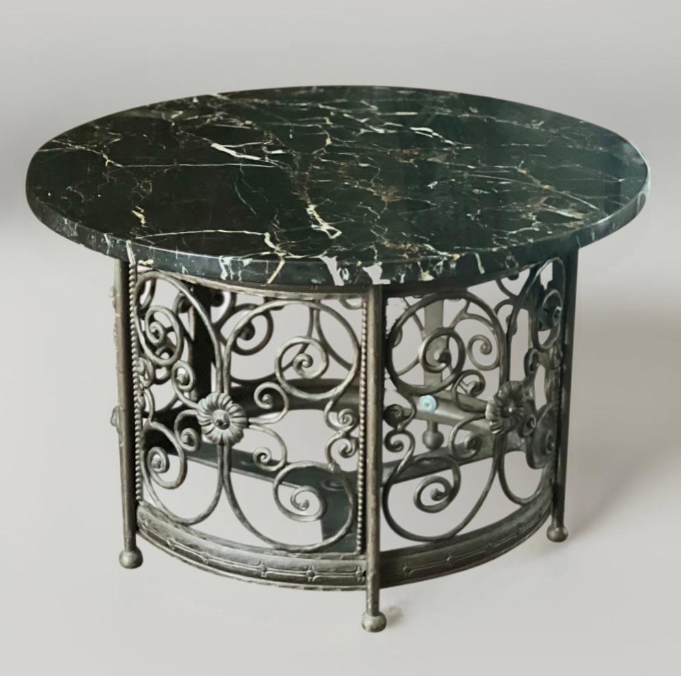 French Art Deco wrought iron garden table with black marble top, c. 1930s.

Wonderful table with a black marble top with white and gold veining. The circular base has intricate iron work with elaborate scrolls, centralized floral motifs, rivet