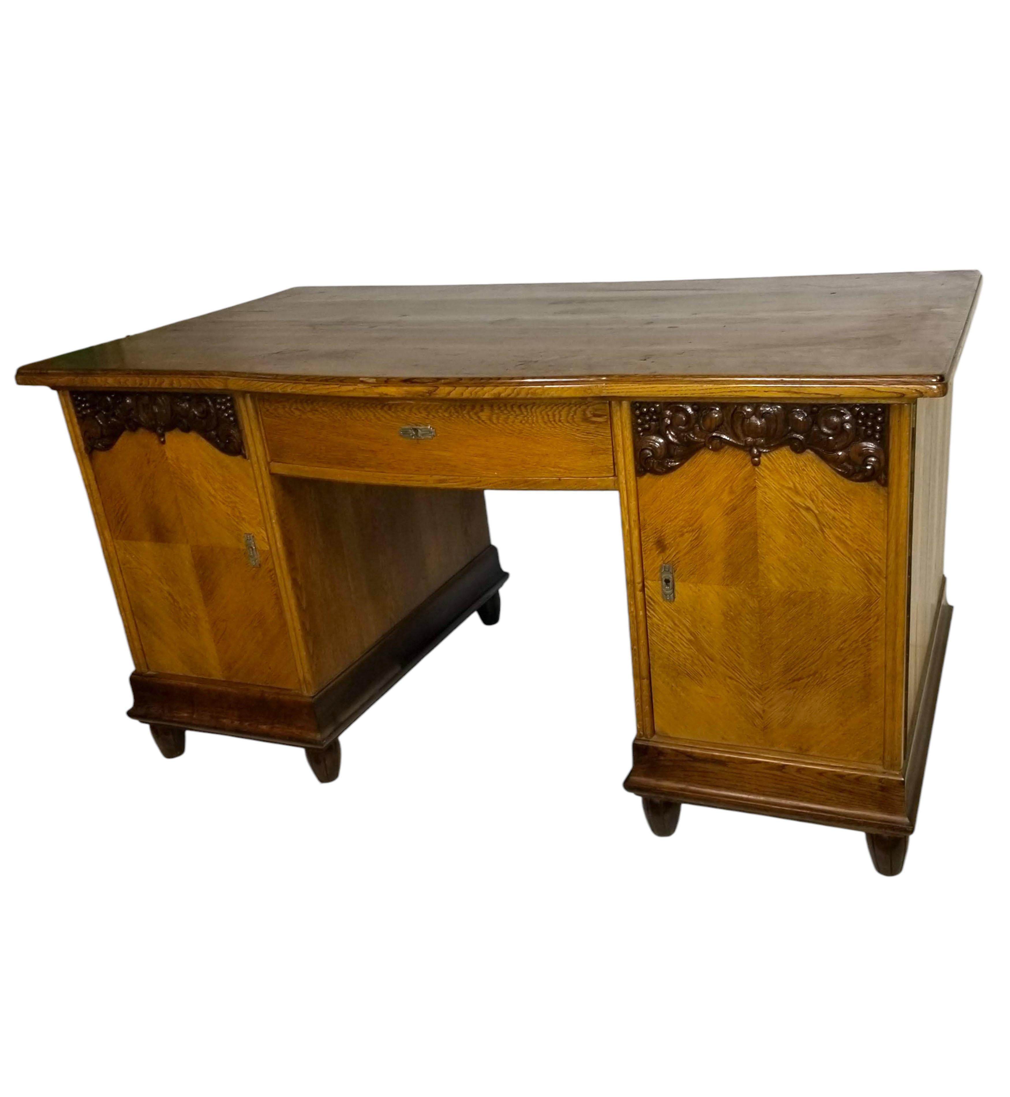 An original and unique French kneehole two-tone desk crafted from hand-carved oak and elevated on eight fluted toupie feet. It features a central drawer and two doors, with one side door unveiling a frieze of three drawers arranged in a stepped