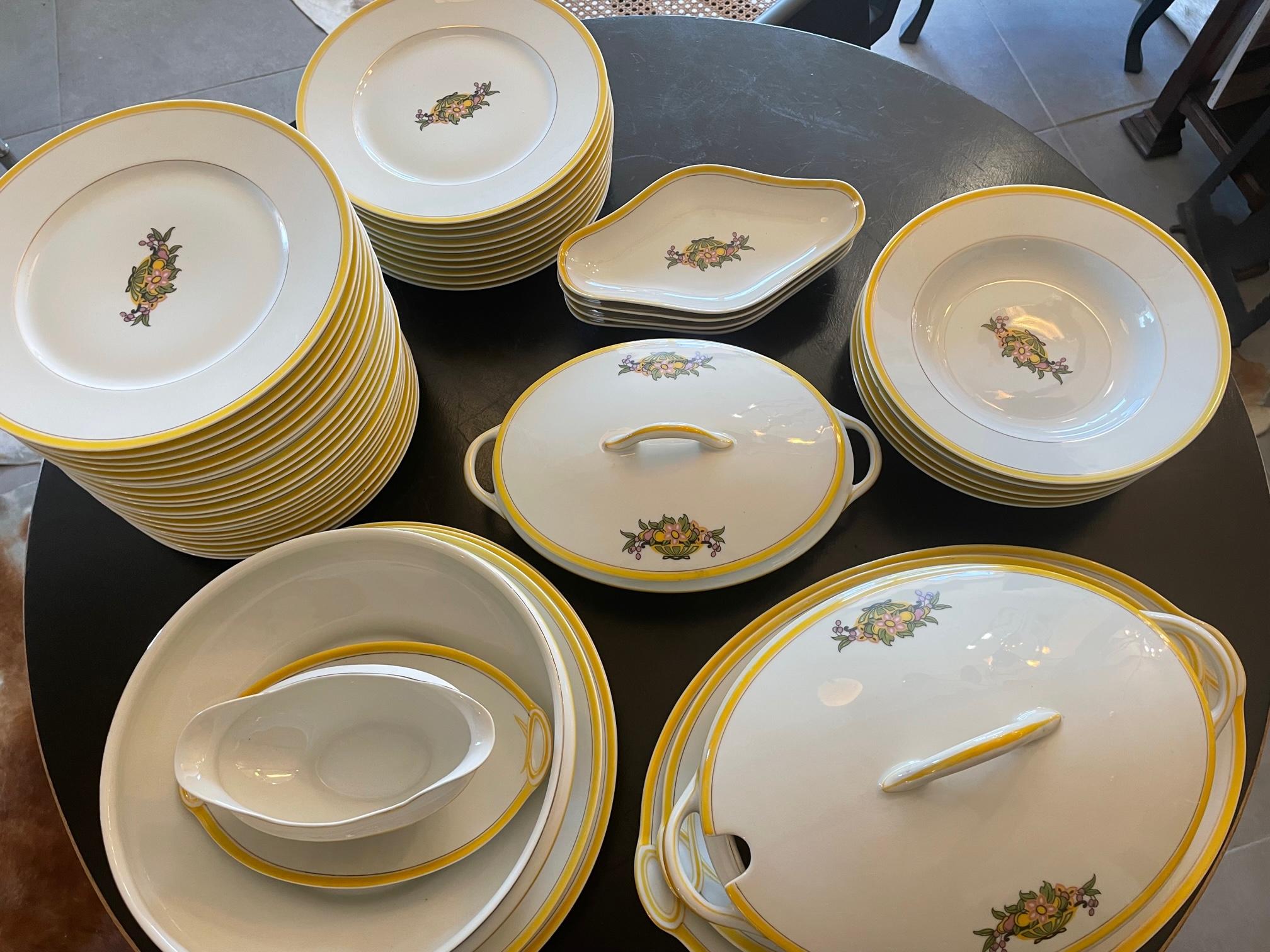 Beautiful Art deco Limoges porcelain dinner service with a yellow border and flower decoration in the middle. 
49 pieces : 
- 31 dinner plates 25 cm
- 4 soup plates 25 cm 
- 2 lidded tureens W35cmXD22cm / W30cmXD18cm 
- 1 salad bowl 26cm 
- 6