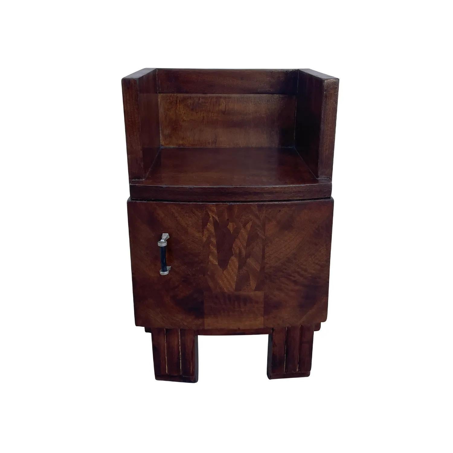 A single, vintage French Art Deco nightstand made of hand crafted Mahogany, in good condition. The small bedside table is composed with an upper shelf and a drawer, supported by four short wooden feet. The small side table is consisting its original