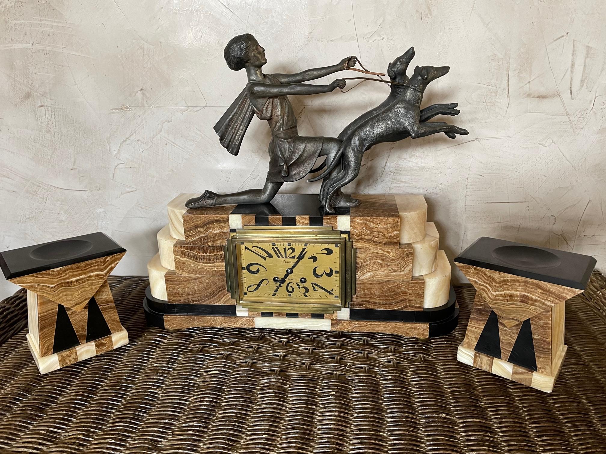 Exceptionnal Art deco Mantel clock in marble and brass representing a women with her two dogs on a leash. 
Clock movement by Perrin (Roanne, France). 
Two marble candle holder. 
Very good condition and quality.
 