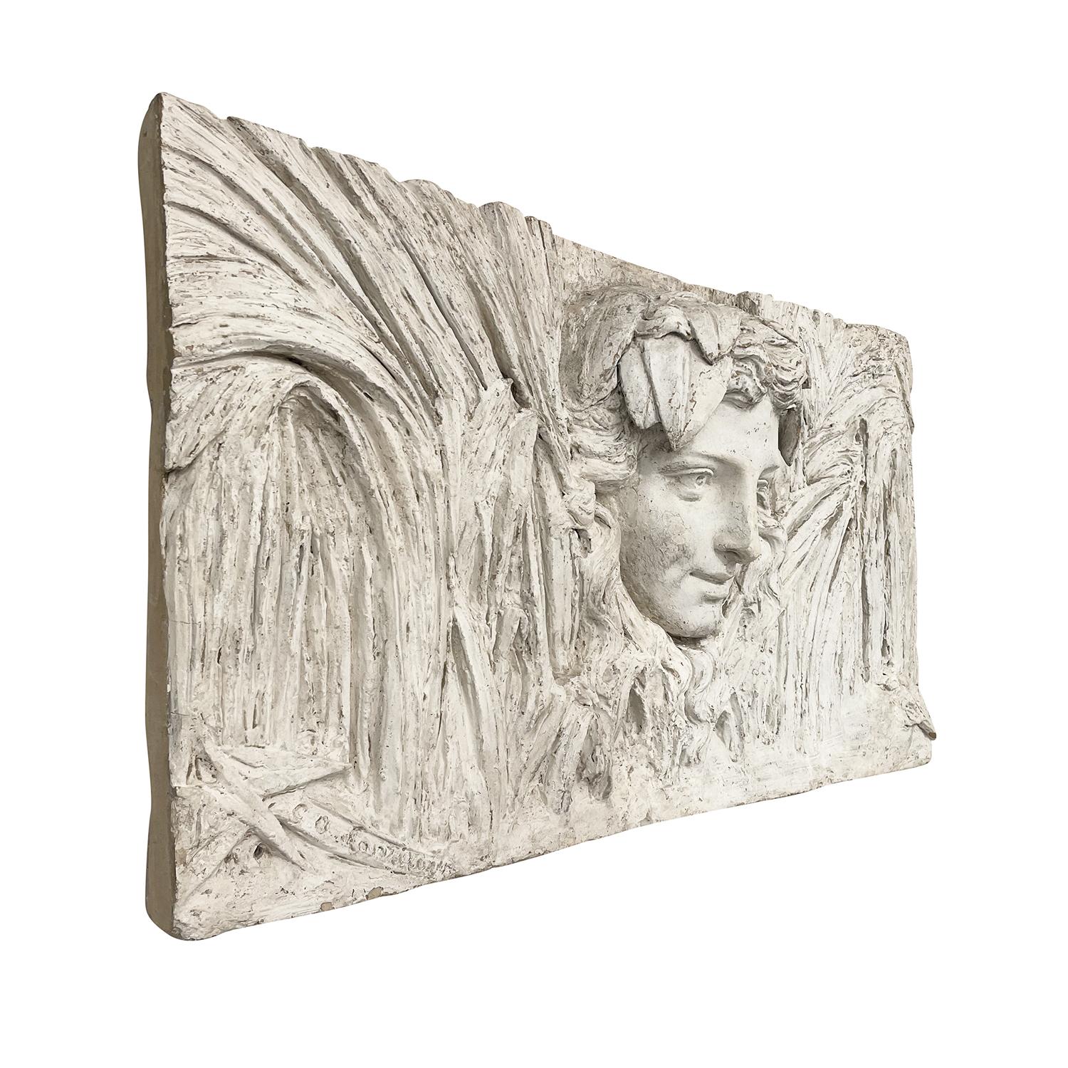 A white, vintage Art Deco French wall, bas relief of a female head made of hand crafted plaster, in good condition. Signed on the lower left. Not recommended for exterior use. Wear consistent with age and use. Circa 1920 - 1930, Paris, France.