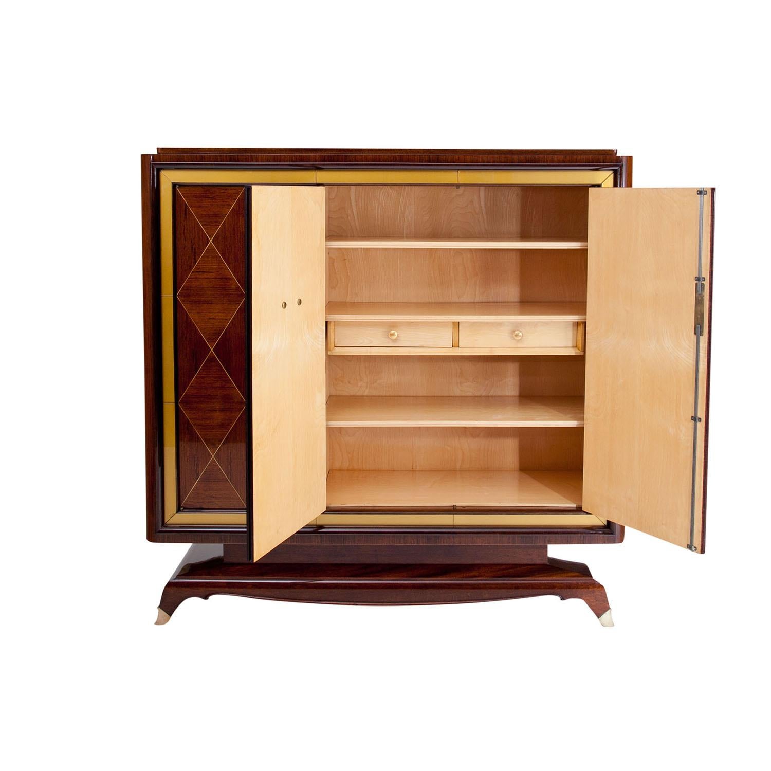 A light-brown, vintage Art Deco French cabinet made of handcrafted polished Rosewood, designed by Jean Desnos and produced by Rambaudi-Dantoine in good condition. The cupboard is composed with three doors, the frame is detailed with a gold-coloured
