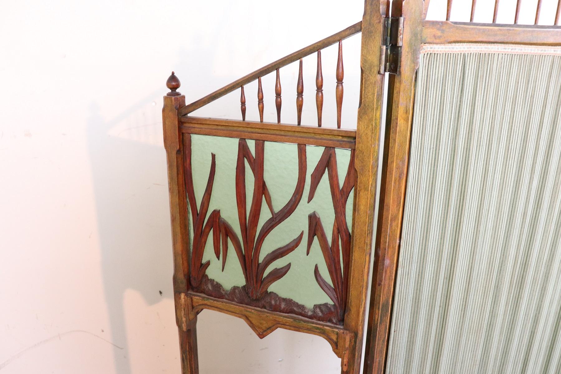 Beautiful important French Art Nouveau Screen in beech wood. There are three panels. The central panel is made of antique green fabric in the upper part small turned columns. The two side panels are characterized by antique green glass with carved