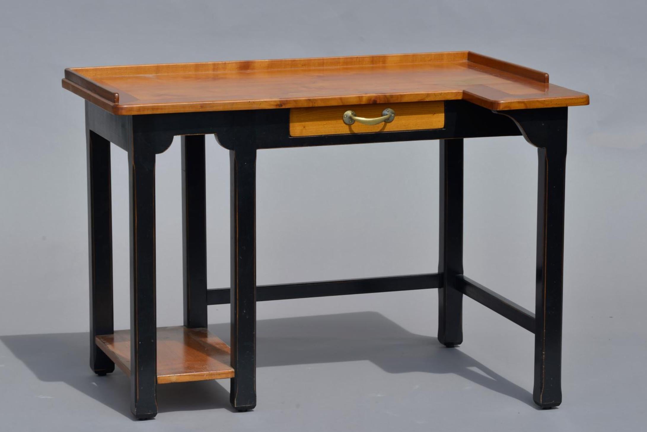 French asymmetrical writing desk made of solid wood in two colors. It is raised on six hand painted in black lags connected with a small shelf on the left side. There is a small drawer in the middle of the front part. Very good condition.
France,