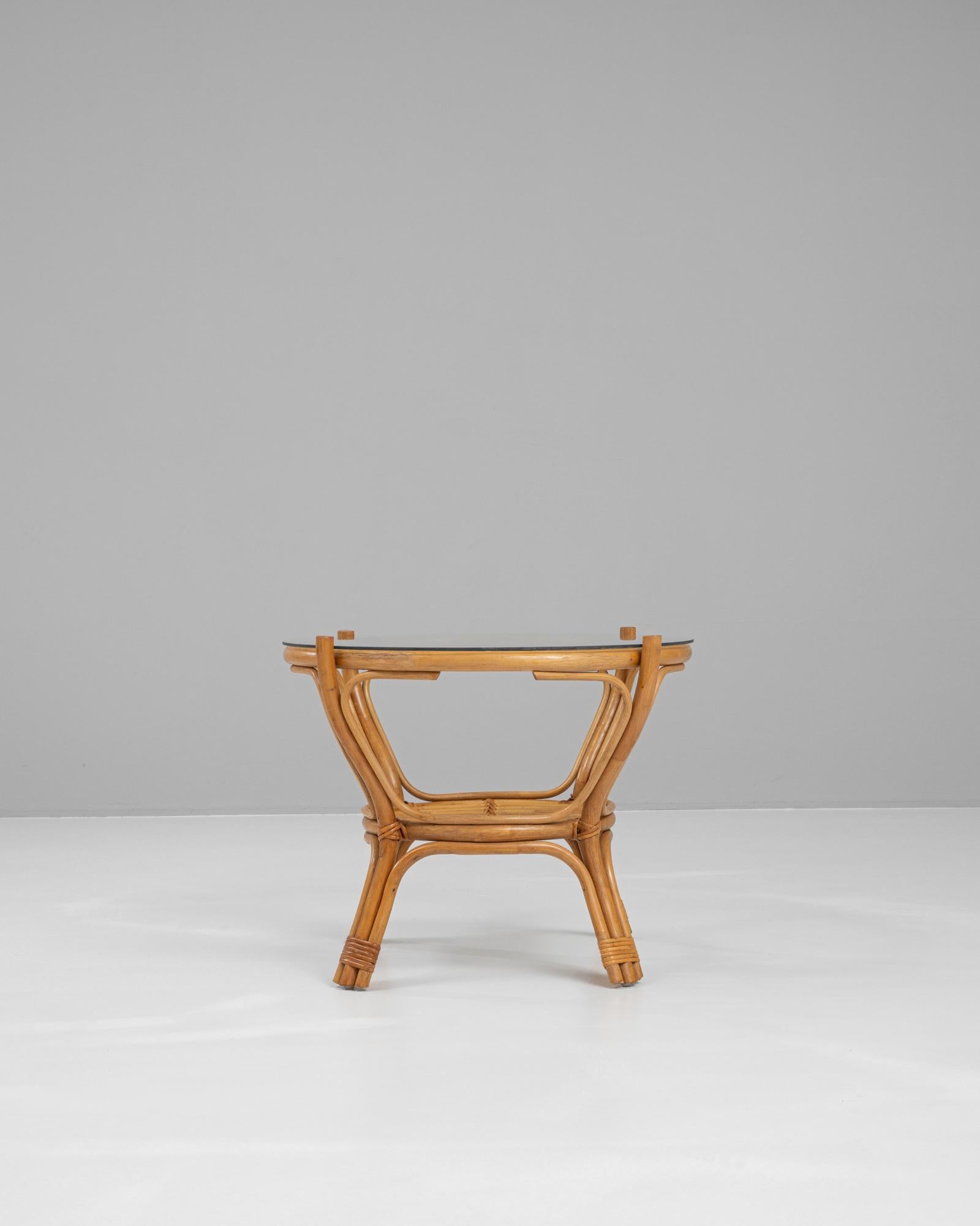 Cette charmante table basse française du XXe siècle présente un mélange sophistiqué de bambou naturel et de verre épuré. La base, fabriquée en bambou durable et élégamment courbée, met en valeur sa texture organique et son attrait intemporel. Son