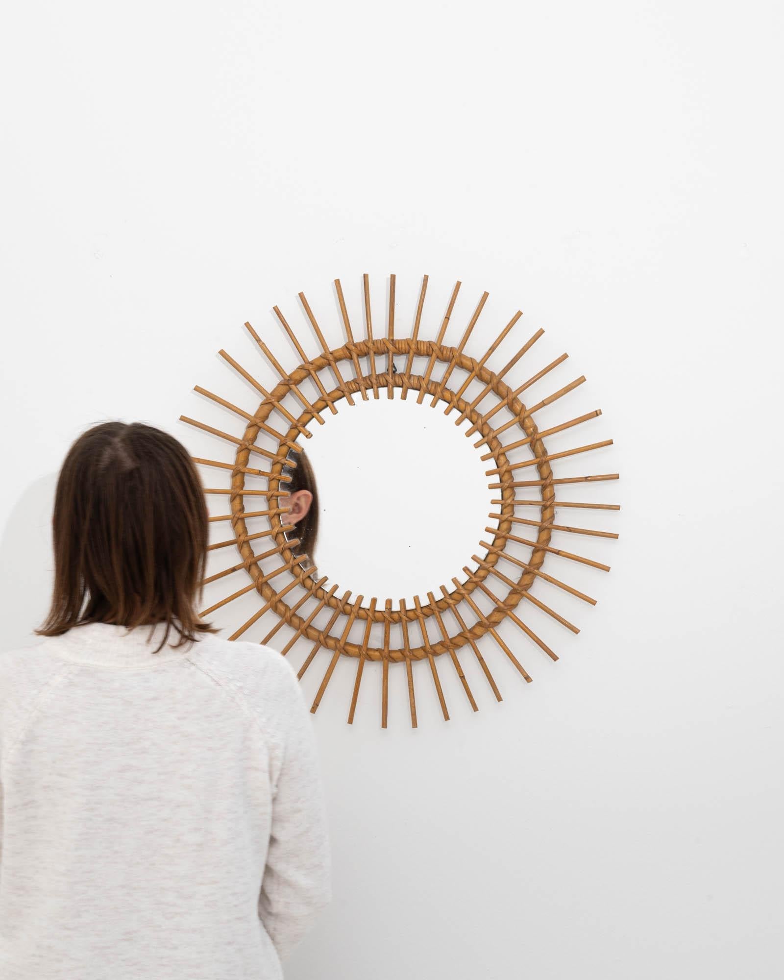 Infuse your space with a touch of organic elegance with this exquisite 20th-century French bamboo mirror. This piece beautifully marries the simplicity of natural materials with intricate craftsmanship. The circular frame, composed of multiple