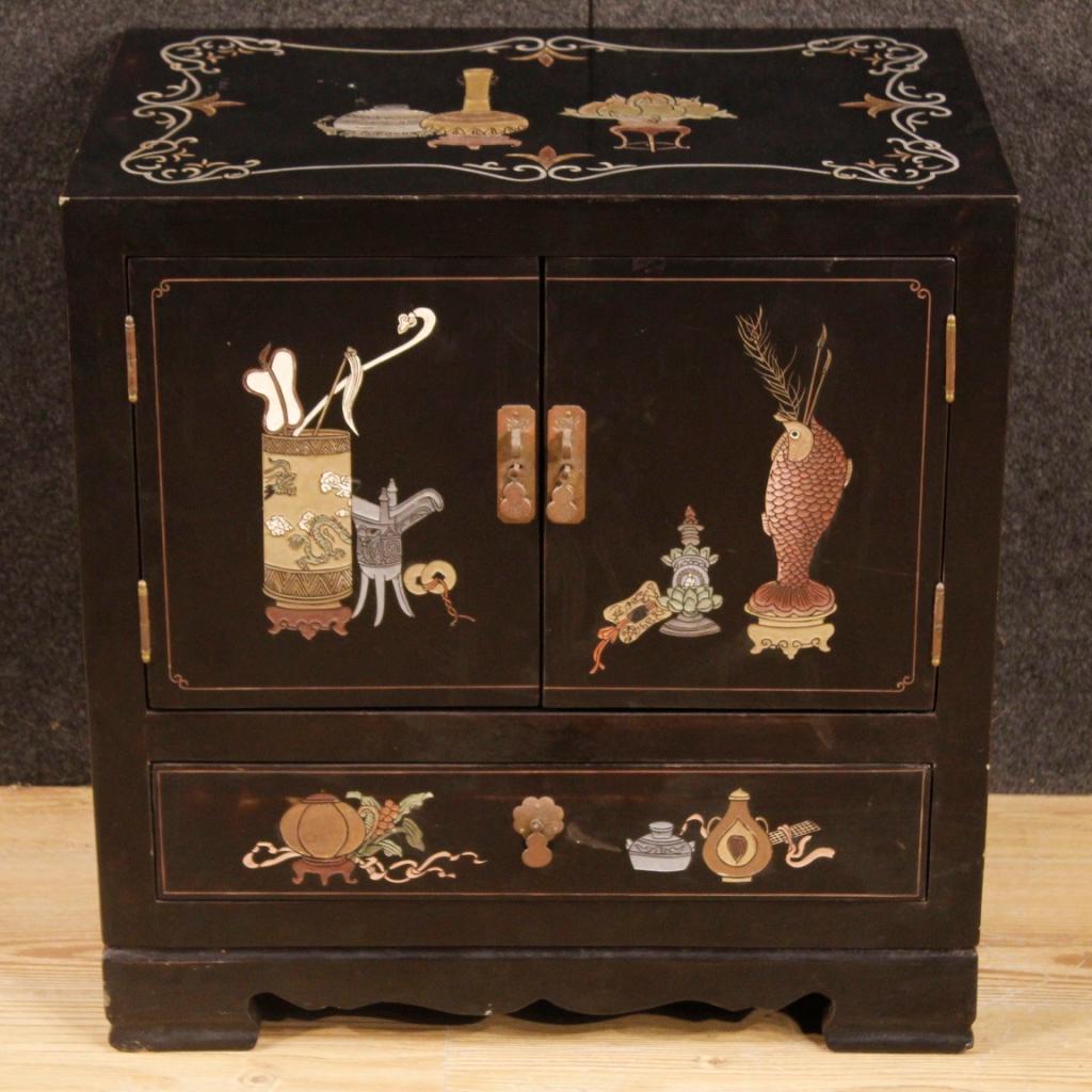 French bedside table from 20th century. Furniture in lacquered, chiselled and painted chinoiserie wood of beautiful line and pleasant decor. Night stand with two doors and an external drawer of good capacity and service. It has some small signs of