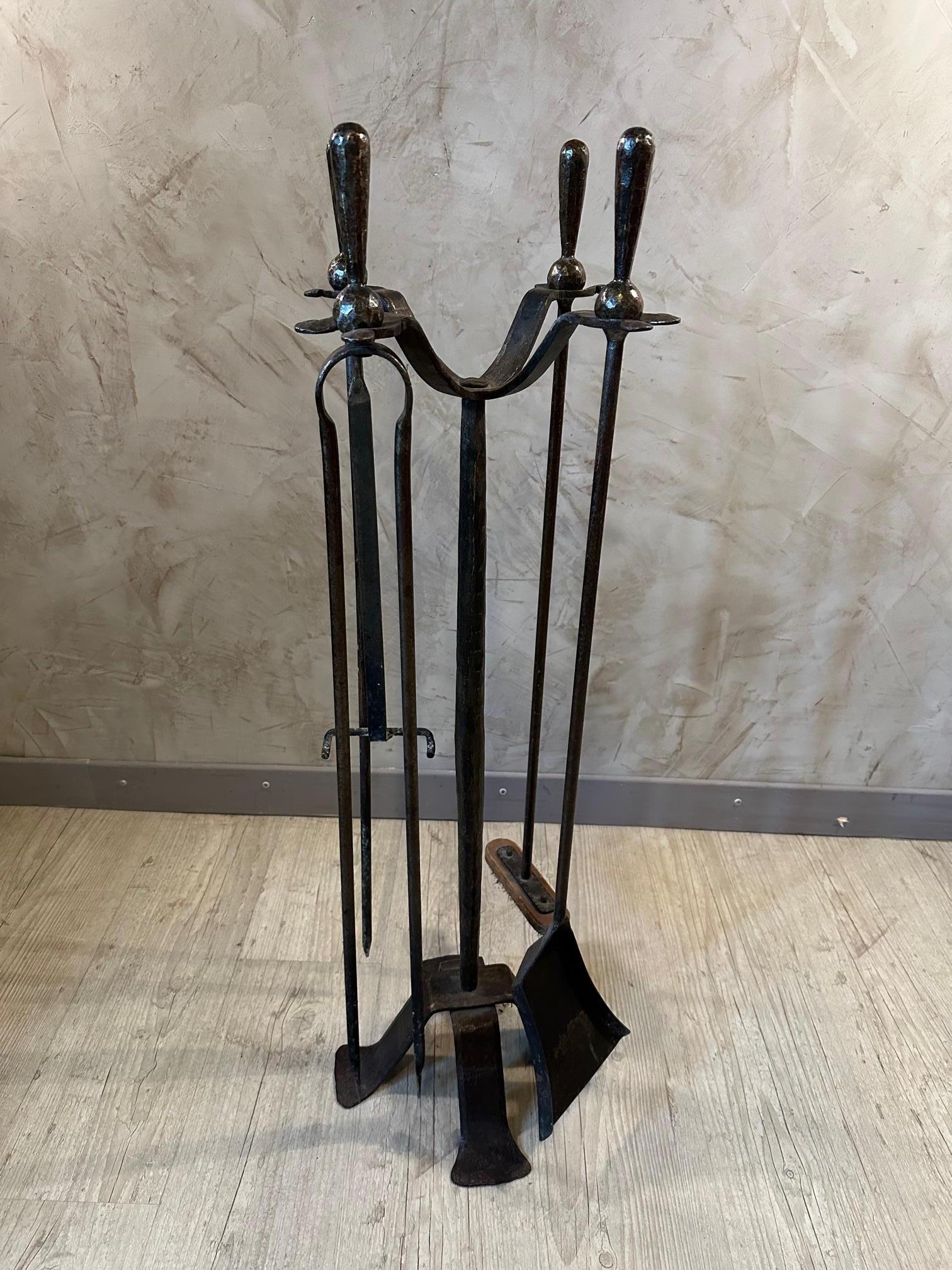 Very nice wrought iron fireplace set dating from the 1950s consisting of five tools for tending a fireplace fire.
Very beautiful blacksmith work, good quality. 
For lovers of handmade pieces.