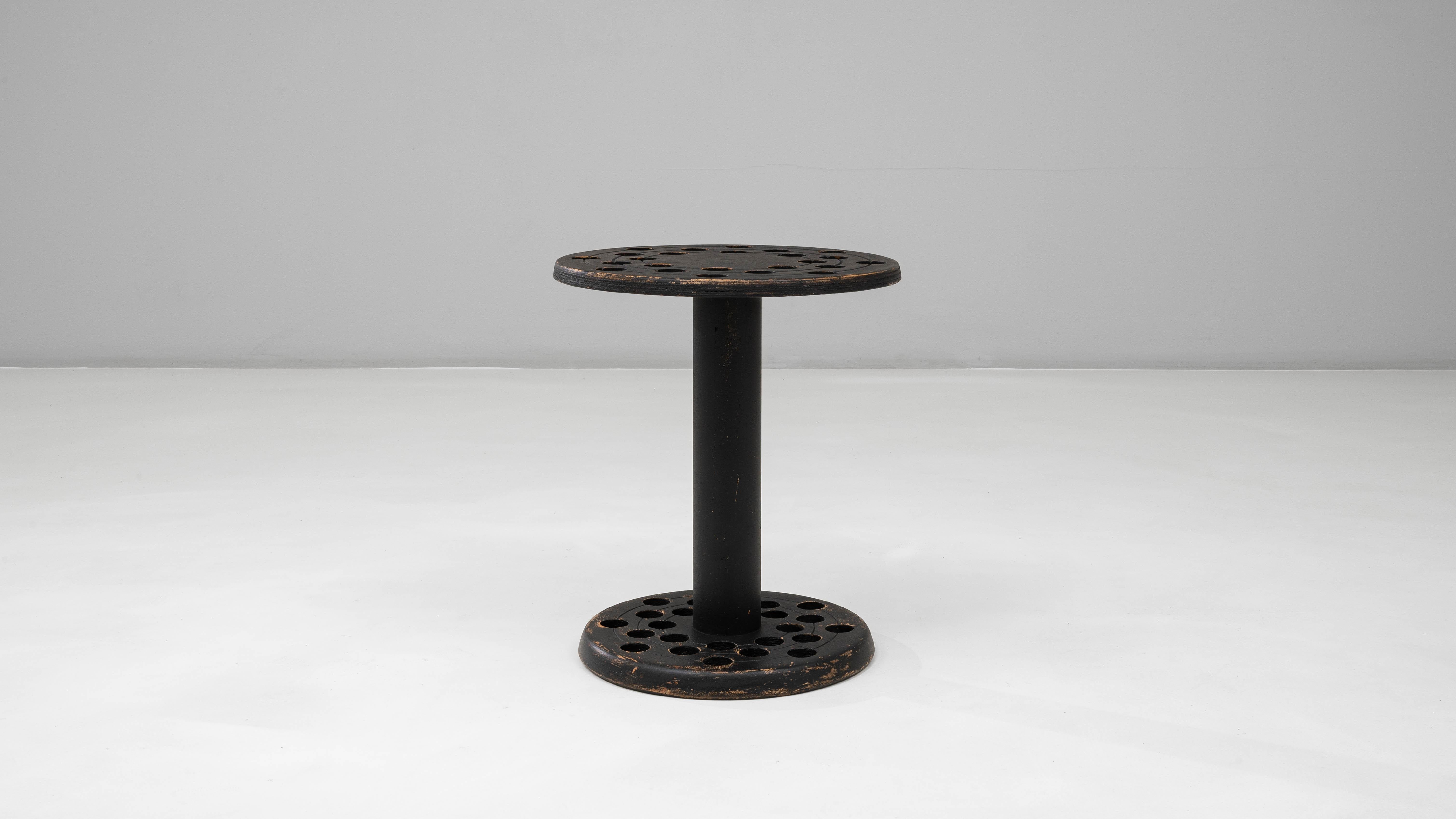 Questo portacanne francese del XX secolo in legno patinato nero ha una caratteristica forma circolare e una silhouette funzionale e minimalista. Realizzato con due piani rotondi collegati da una colonna centrale, il supporto incorpora molteplici