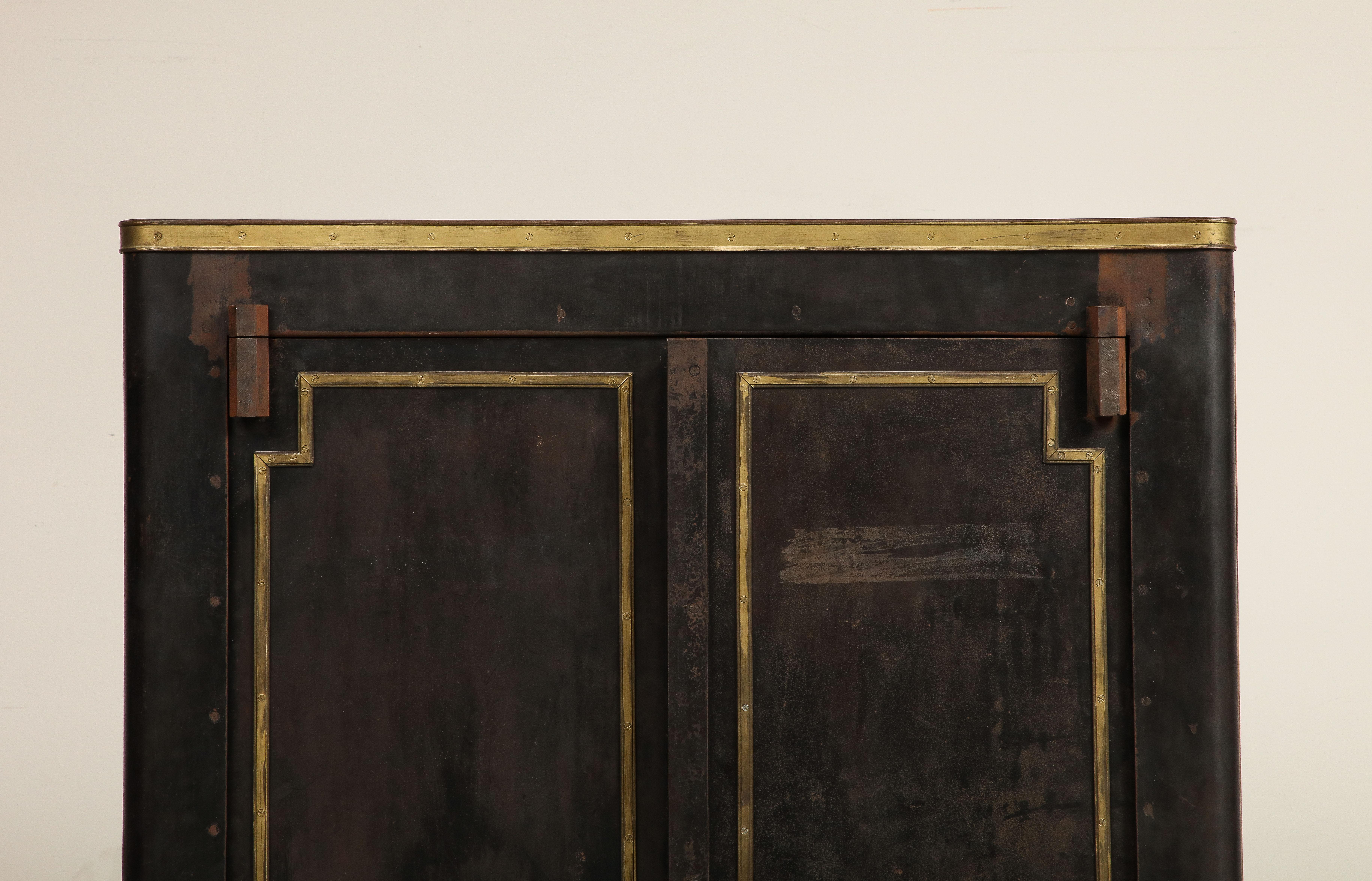 Impressive 20th century vintage French blackened metal cabinet or armoire with brass accents and a beautiful patina. Adjustable metal interior shelving. Condition as shown with rust/oxidation marks. 